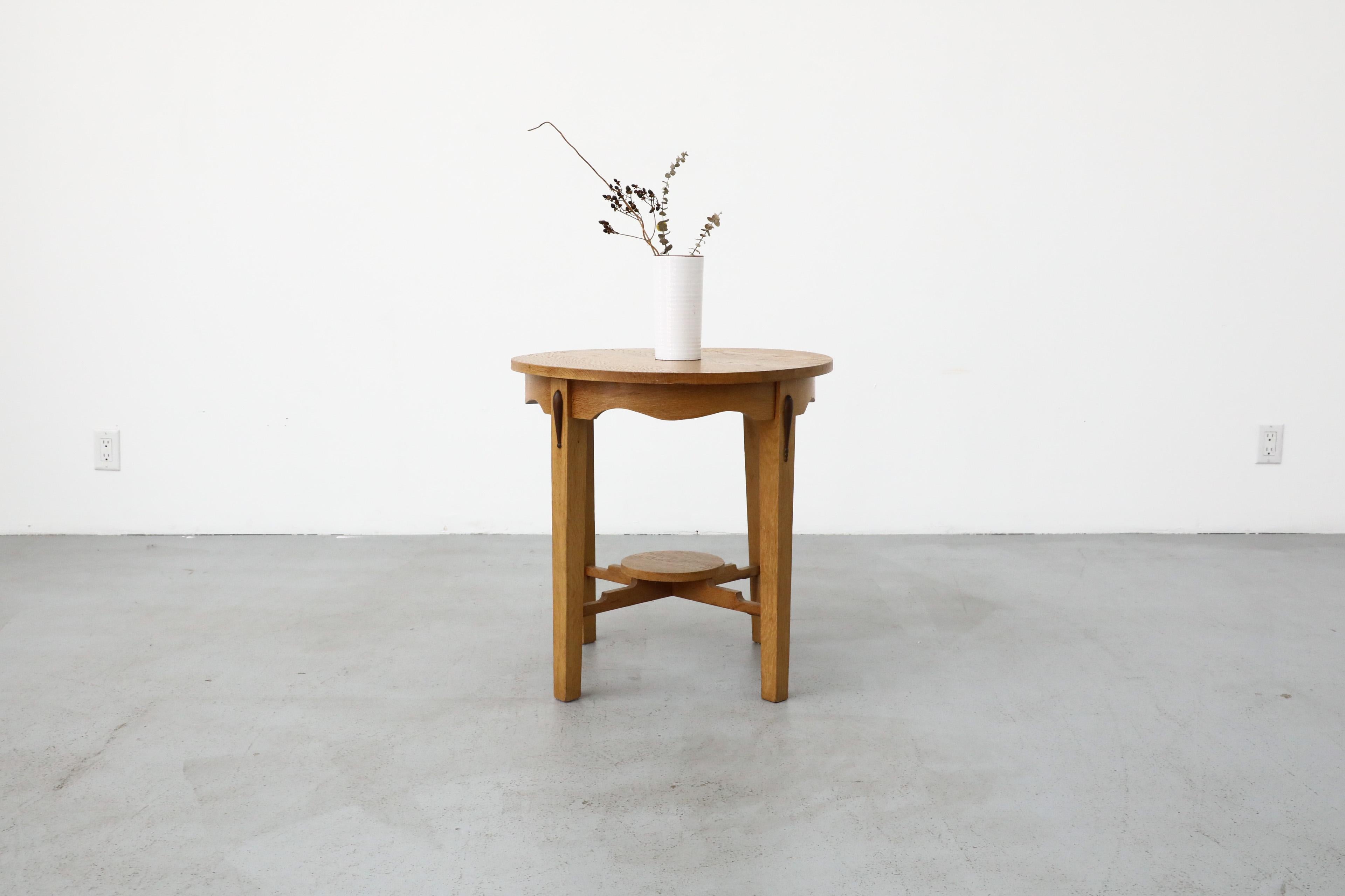 Deco Oak side table or plant stand with round top and little lower shelf. Charming piece with beautiful details. In original condition with wear consistent with age and use. Other similar tables are available and listed separately.