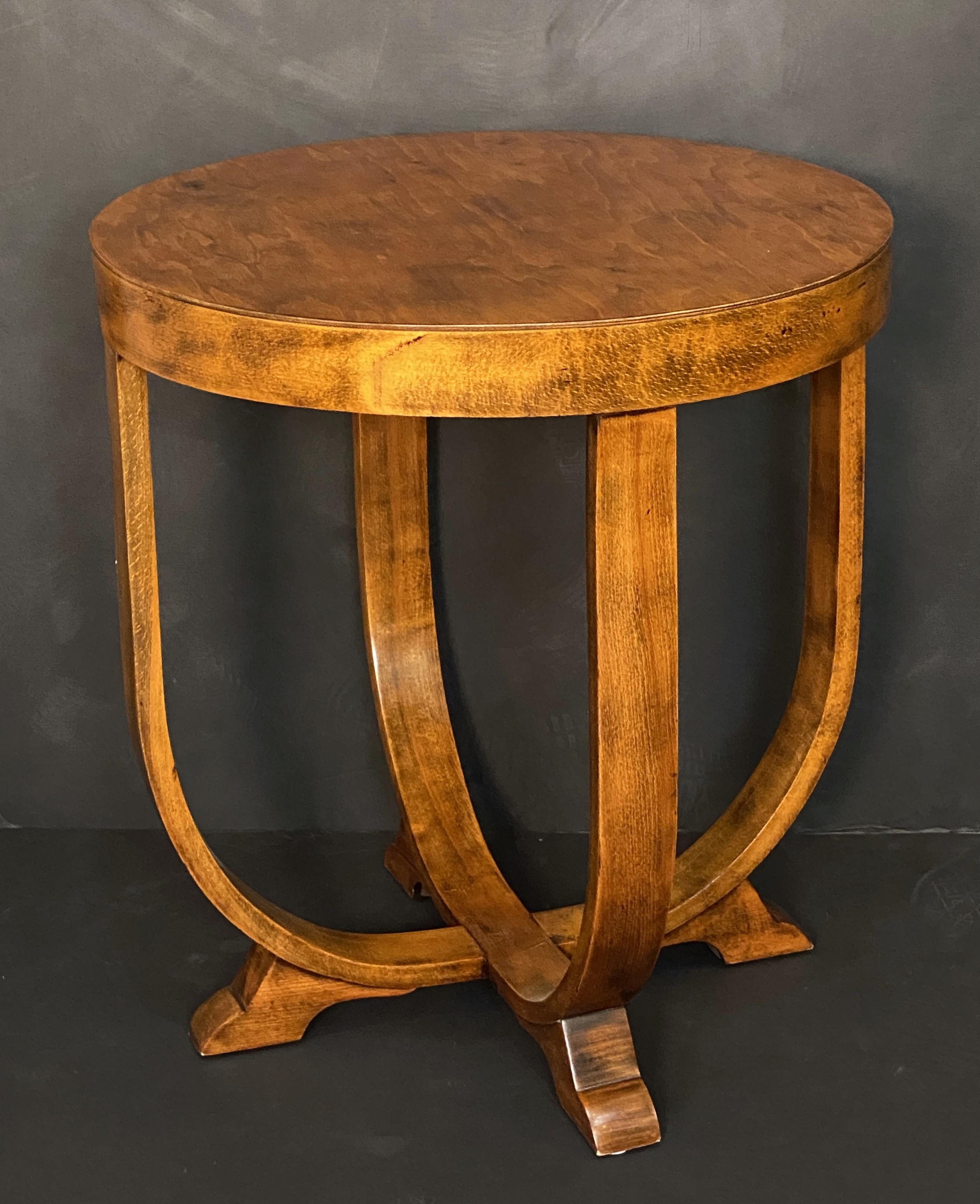 A fine Italian table of red beech wood, from the Art Deco period, featuring the traditional round or circular top over a base with four gracefully curved legs that meet at a central point on the floor, terminating in shaped feet.
This design is