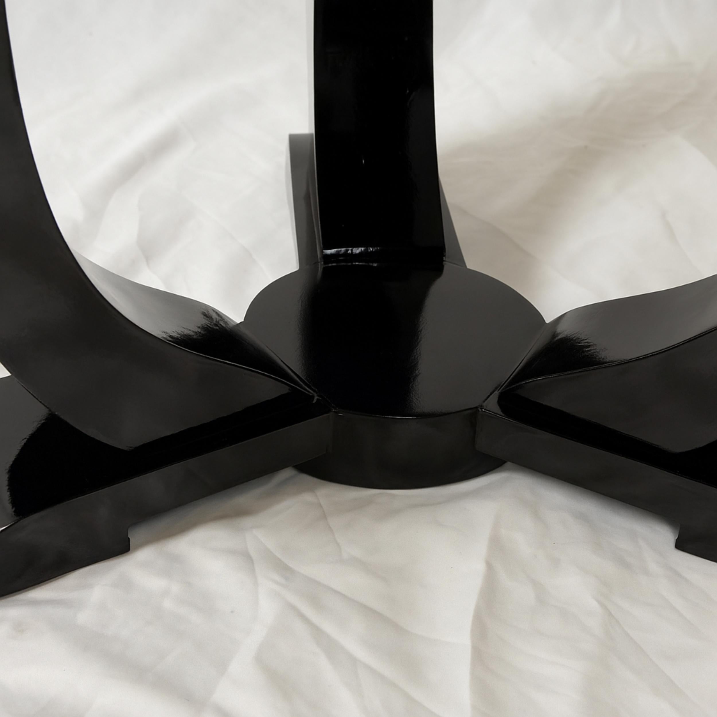 Cette table d'appoint Art déco en noyer laqué noir, datant des années 1930 en France, a été conçue avec une structure ronde. Elle comporte trois pieds gracieusement incurvés reliés à une base circulaire.

Véritable pièce d'apparat, cette table