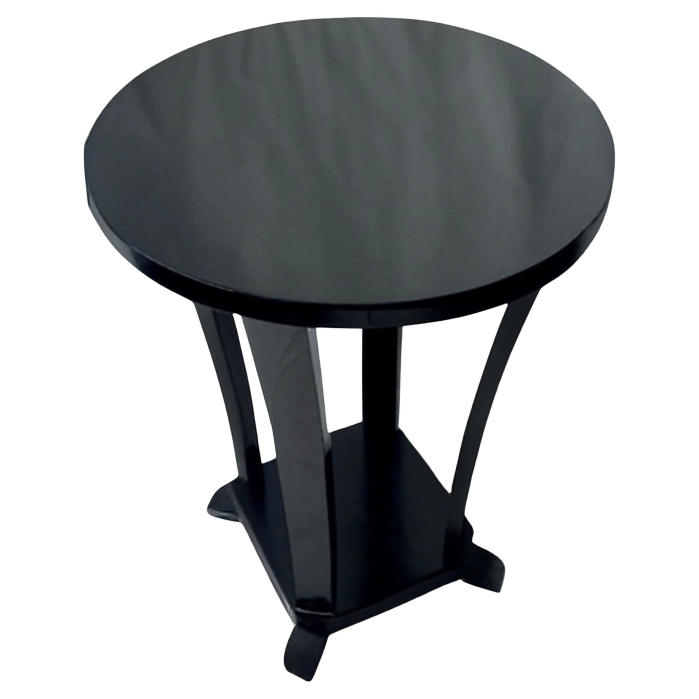 Cette table d'appoint Art déco en noyer laqué noir, datant de la France des années 1930, a été conçue avec une structure ronde à deux niveaux. Elle comporte quatre pieds gracieusement incurvés reliés à une base circulaire.

Véritable pièce