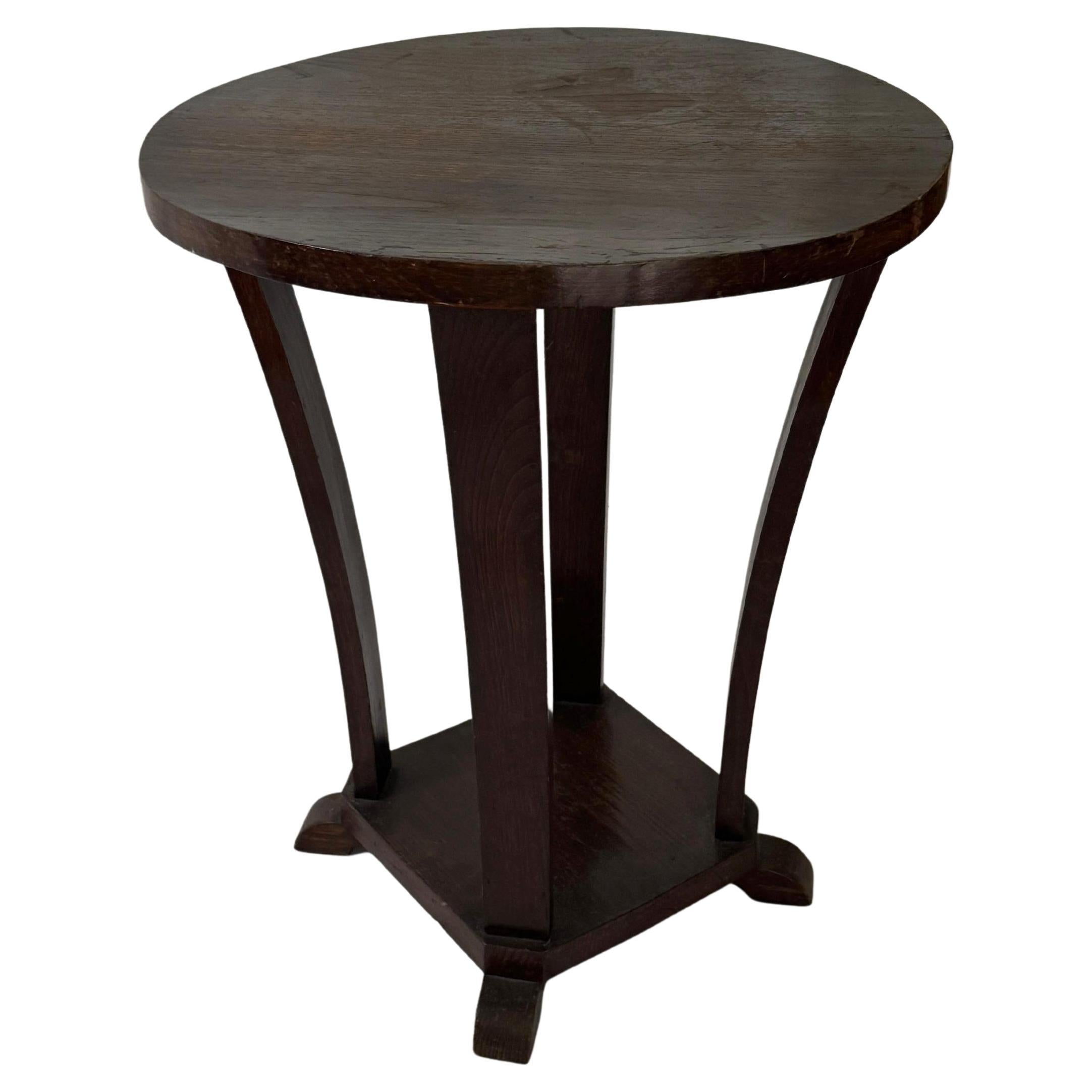Cette table d'appoint Art déco en noyer laqué noir, datant de la France des années 1930, a été conçue avec une structure ronde à deux niveaux. Elle comporte quatre pieds gracieusement incurvés reliés à une base circulaire.

Véritable pièce