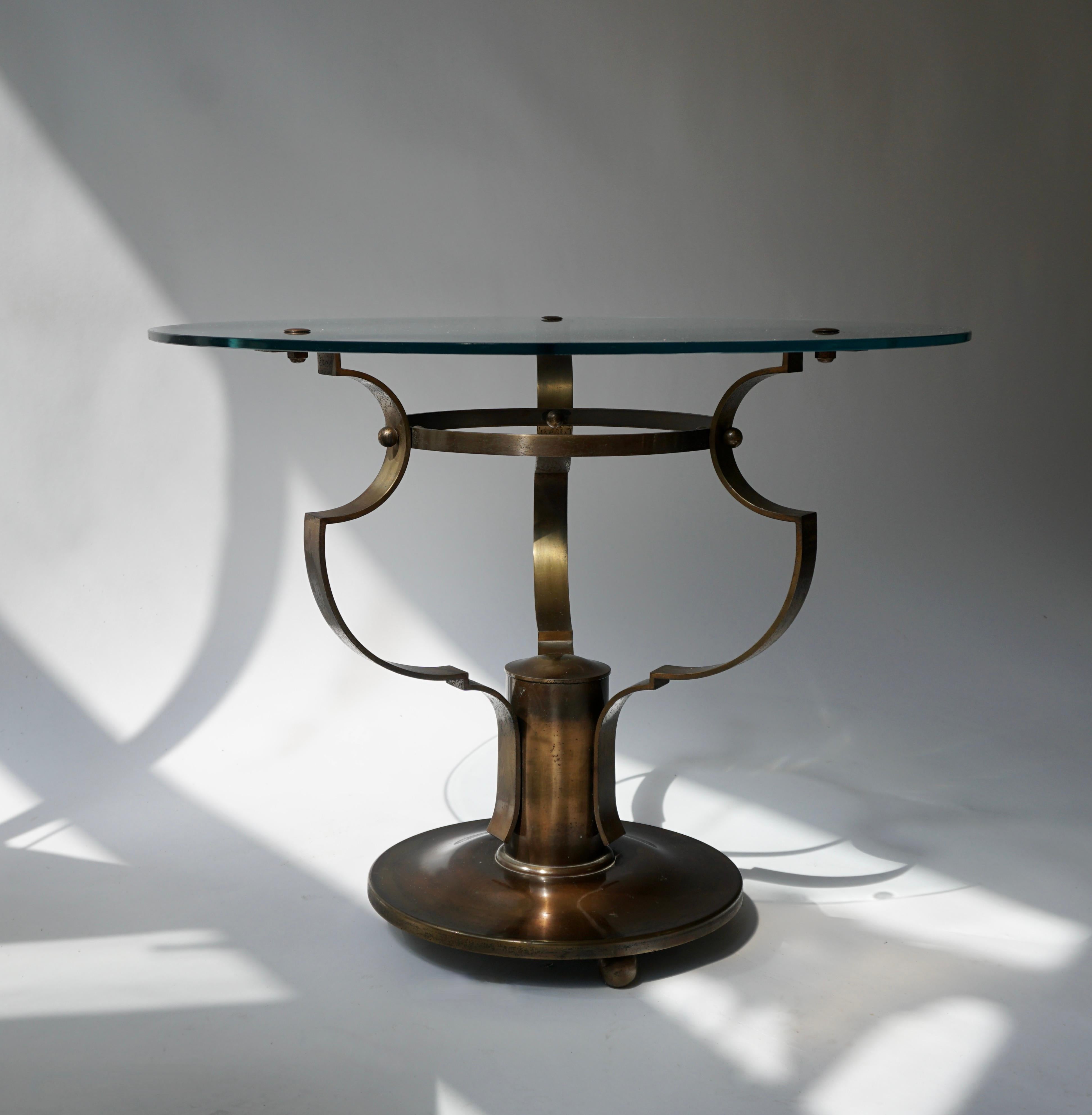 Original Art Deco round three-legged side table or gueridon in glass and bronze.
Mde in Belgium 

Dimensions: H 47 cm x Ø 60 cm.