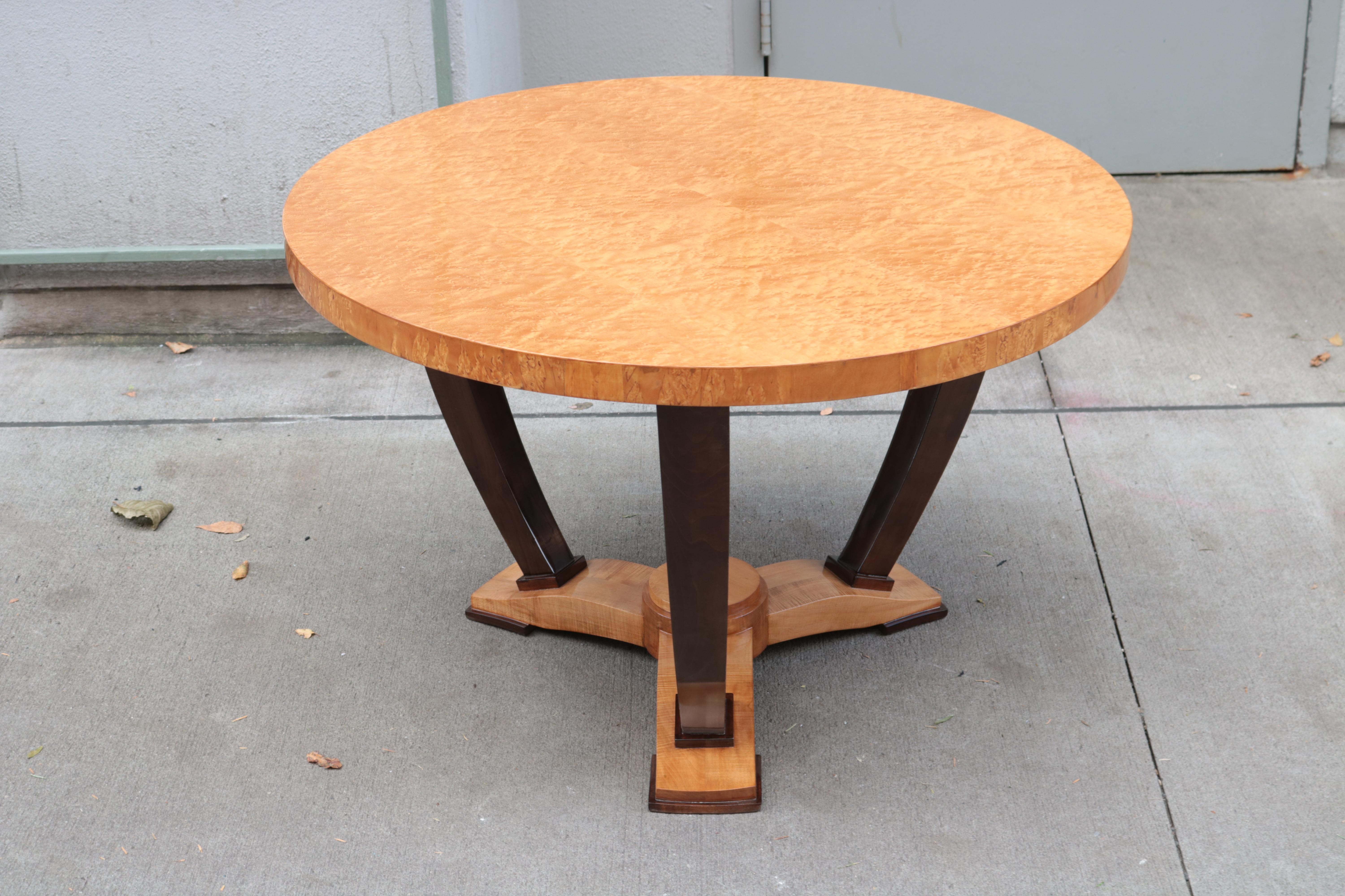 An Art Deco round side table.
Bird's-eye maple with dark stained legs
mounted on a tripod base.
 