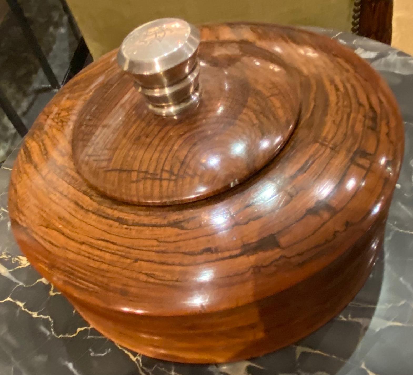 Art Deco round wood box with silver faceted monogrammed top. Unusual faceted carved round solid wood box. Well made with a fitted top, this box might be used to store some very special objects: jewelry, smoking paraphernalia or your favorite objects