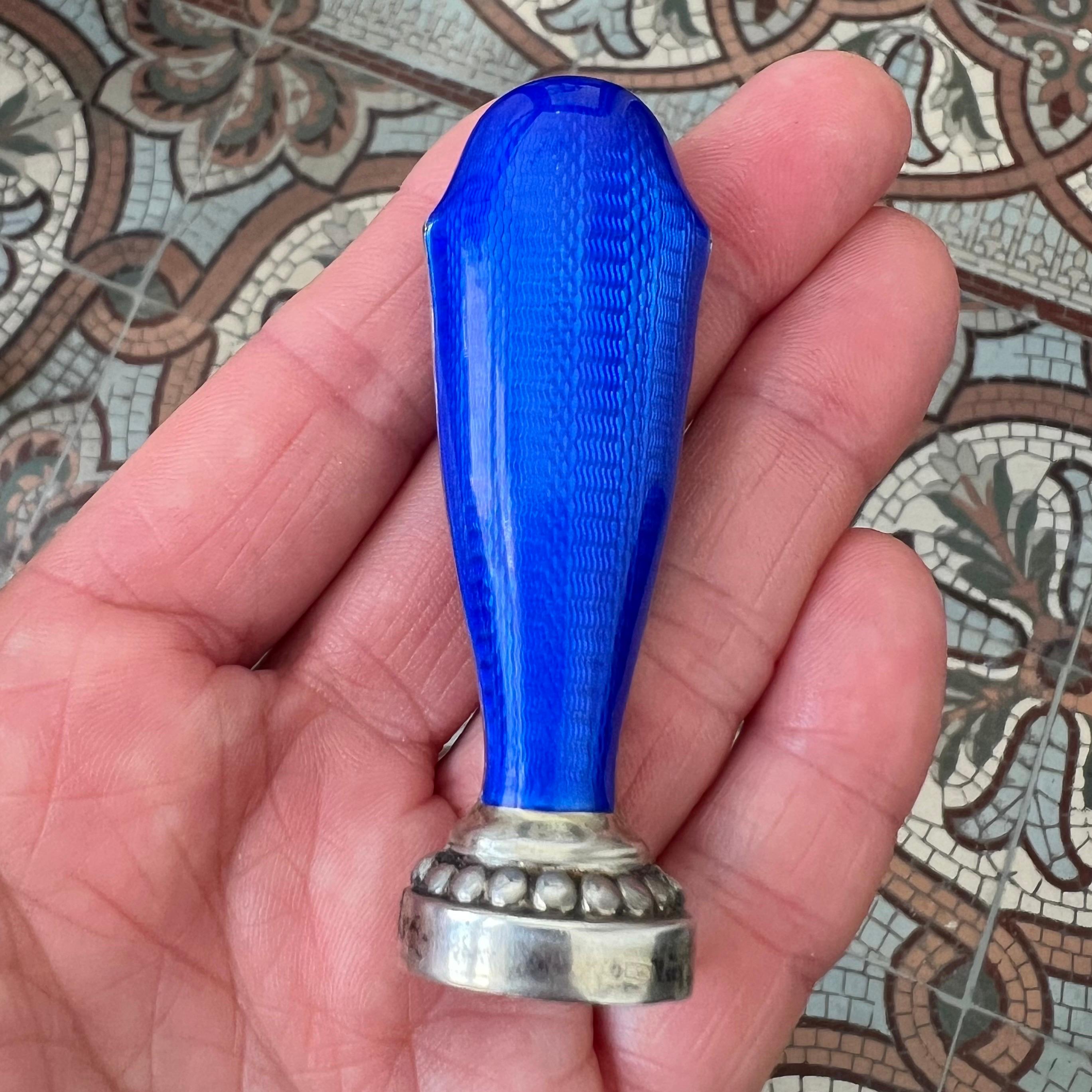 A refined and elegant solid silver seal, crafted in Finland in 1927, distinguished by its striking Imperial blue guilloché enamel handle. The tapered form is entirely overlaid with translucent enamel, allowing the fine engine-turned wave pattern