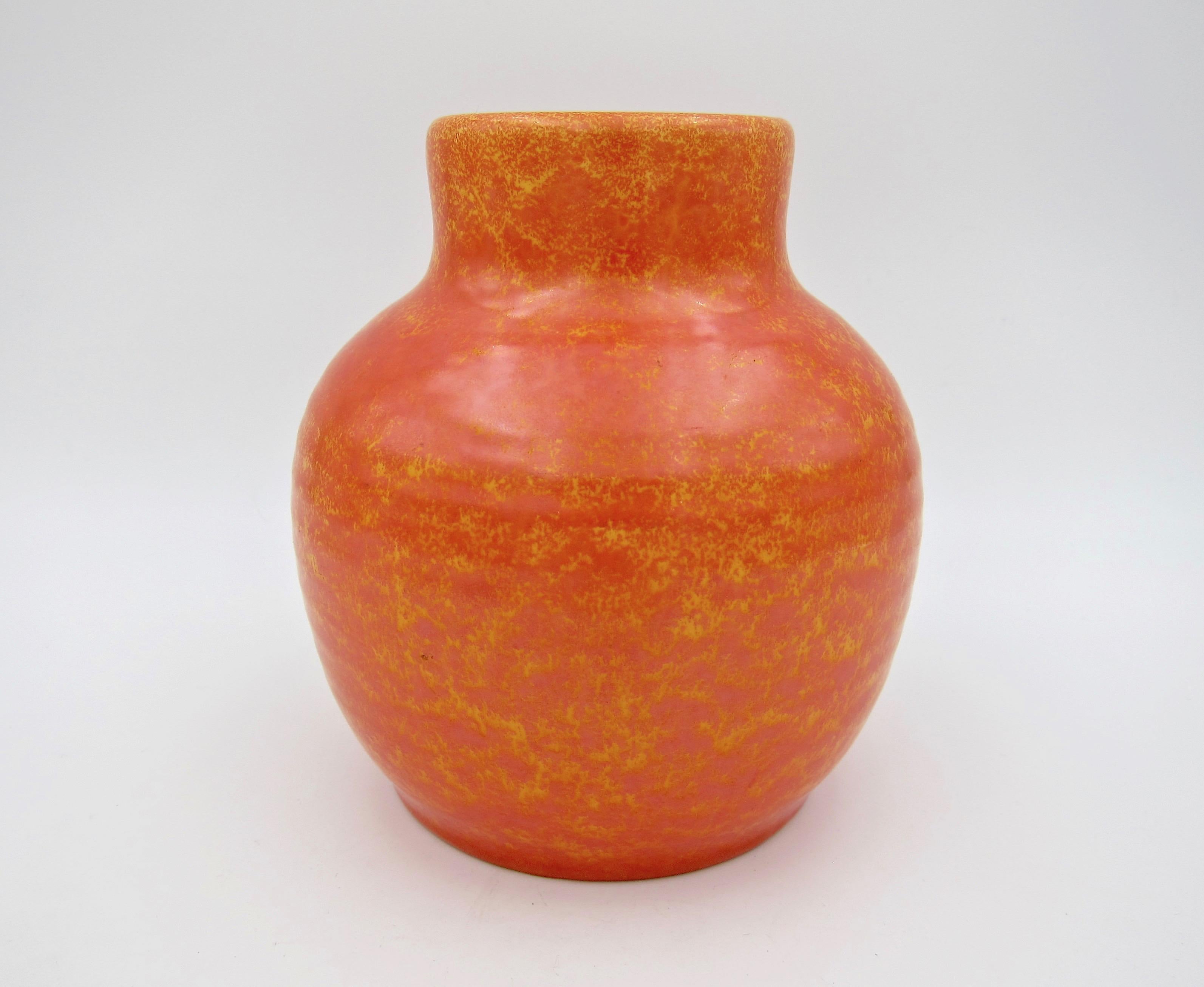 An English Royal Lancastrian art pottery vase with a bold orange vermilion glaze by Edward Thomas Radford dating circa 1920-1933. The Art Deco vase was hand-raised and features a short cylindrical neck and ribbed ovoid body with a mottled 