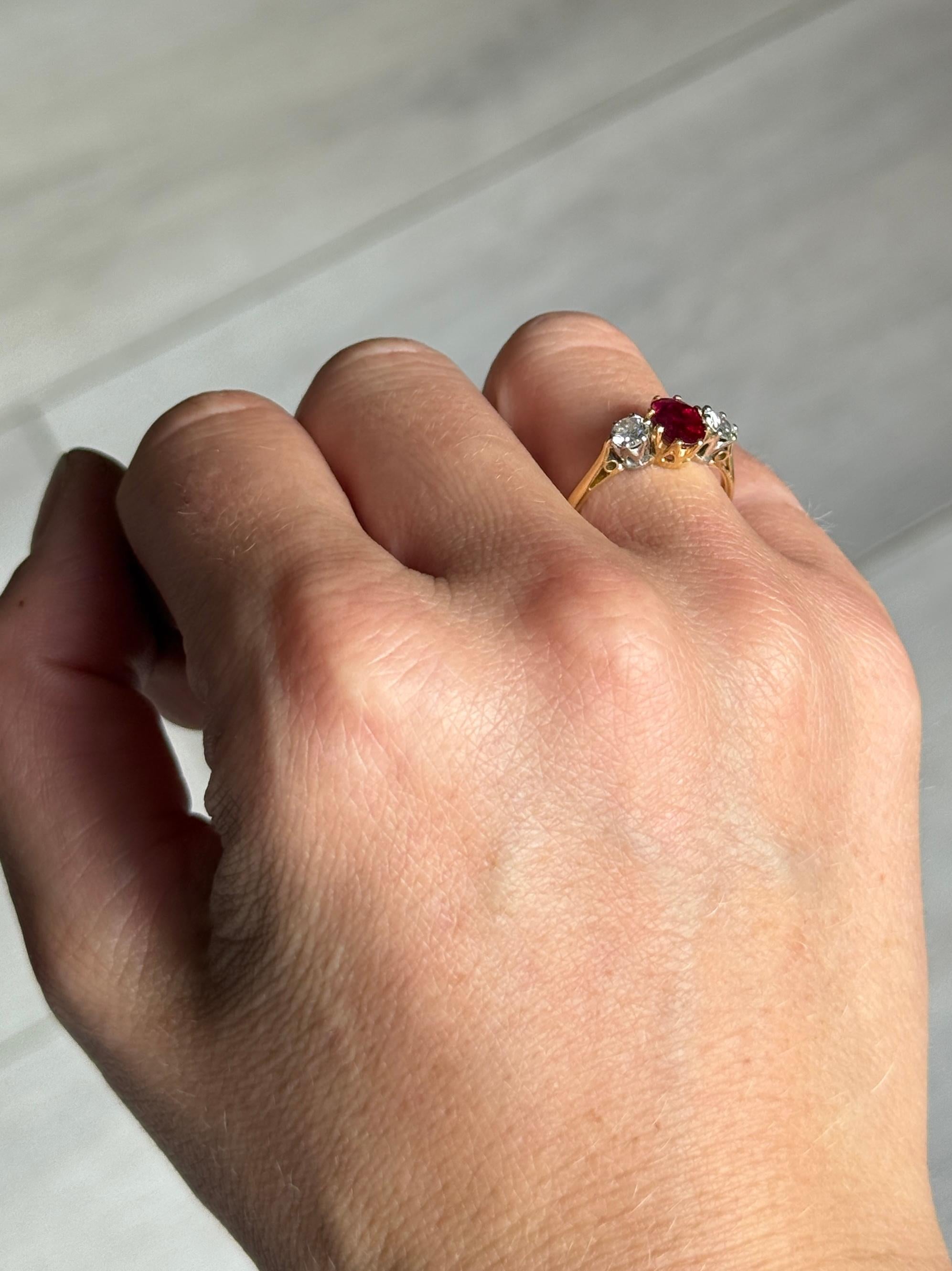 Der zentrale Rubin in diesem glänzenden Ring aus 18-karätigem Gold hat eine Größe von 70 Pfund. Die Diamanten, die auf beiden Seiten dieses Steins sitzen, messen jeweils 20 Pence. 

Ring Größe: L 1/2 oder 6 
Breite der Oberfläche: 7 mm 
Höhe ohne