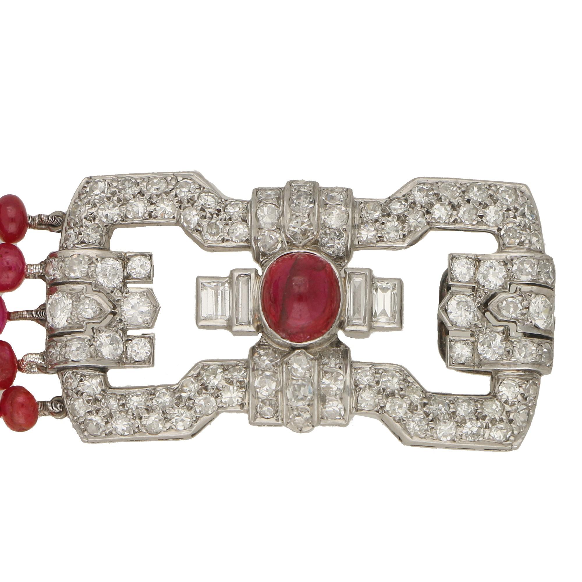 A beautiful Art Deco ruby and diamond beaded bracelet set and fastened with a geometric platinum clasp. 

The bracelet is estimated to be from the early 1930's and is composed of five strands of polished cabochon ruby beads. The beads range from a