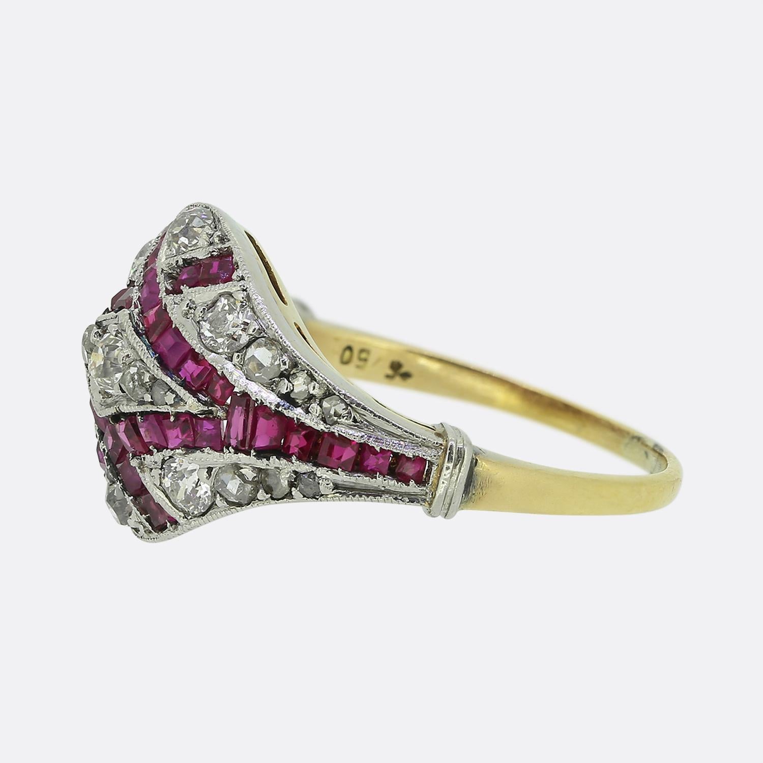 Nous avons ici une exceptionnelle bague bombe en rubis et diamants réalisée à une époque où le style Art déco était à son apogée. Une face concave en forme de dôme accueille un superbe ensemble de rubis et de diamants. Des détails de milgrain