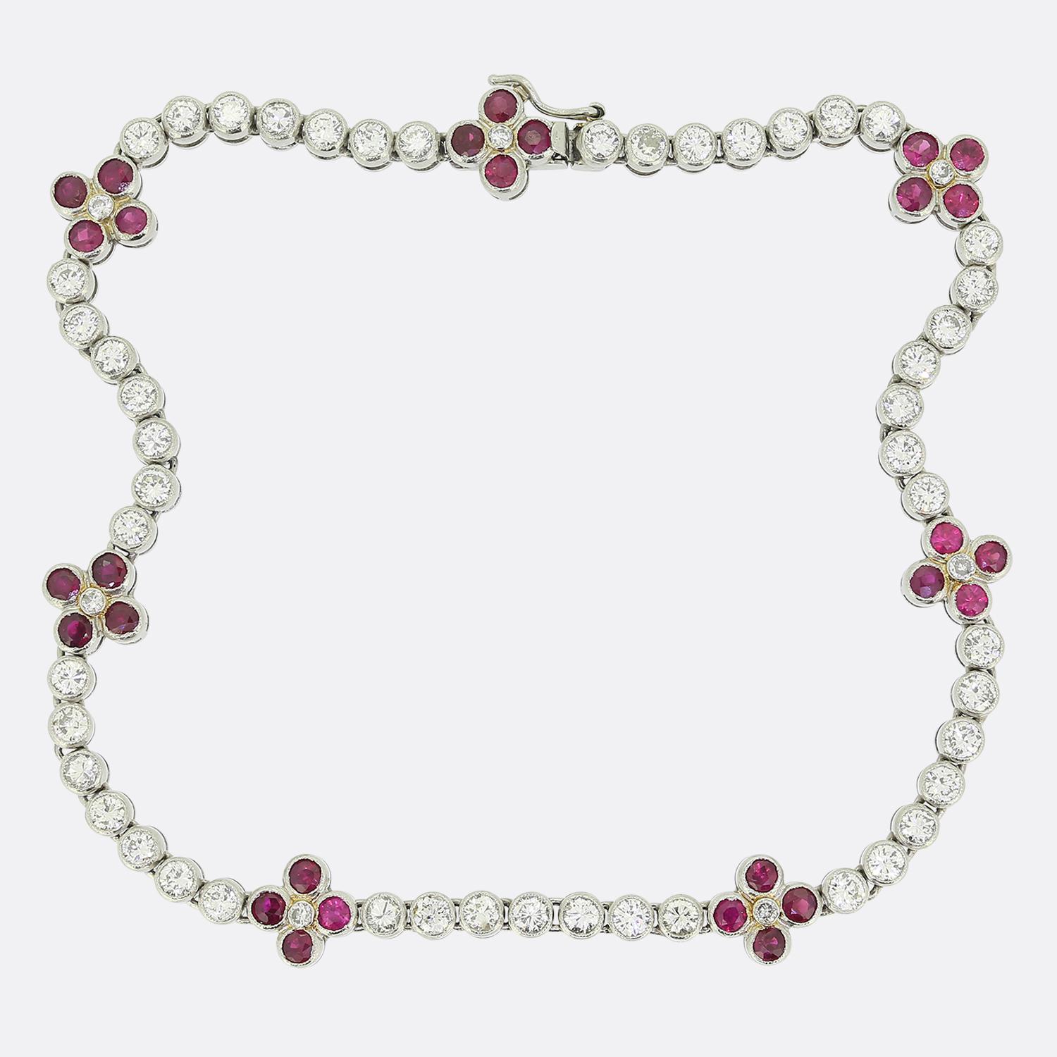 Here we have an exquisite Art Deco bracelet featuring a series of round brilliant-cut diamonds, each meticulously set in a continuous line, creating a seamless flow of sparkle. Interspersed throughout the design are clusters of round-cut rubies with