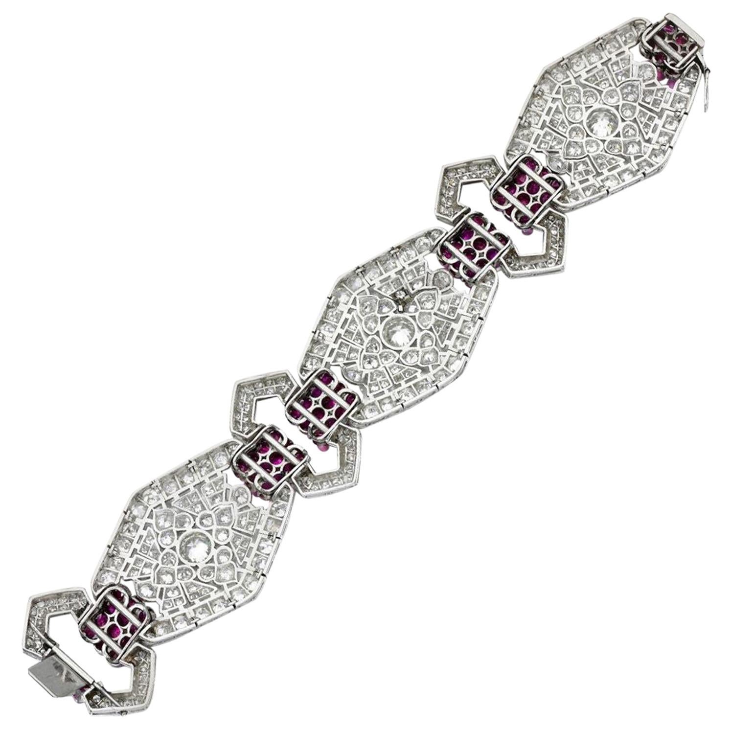 Of geometric design, this stunning Art Deco bracelet is composed of pierced hexagonal plaques spaced with buckle motifs, set with circular-cut rubies and single- and circular-cut diamonds, length approximately 175mm, French assay marks and maker's