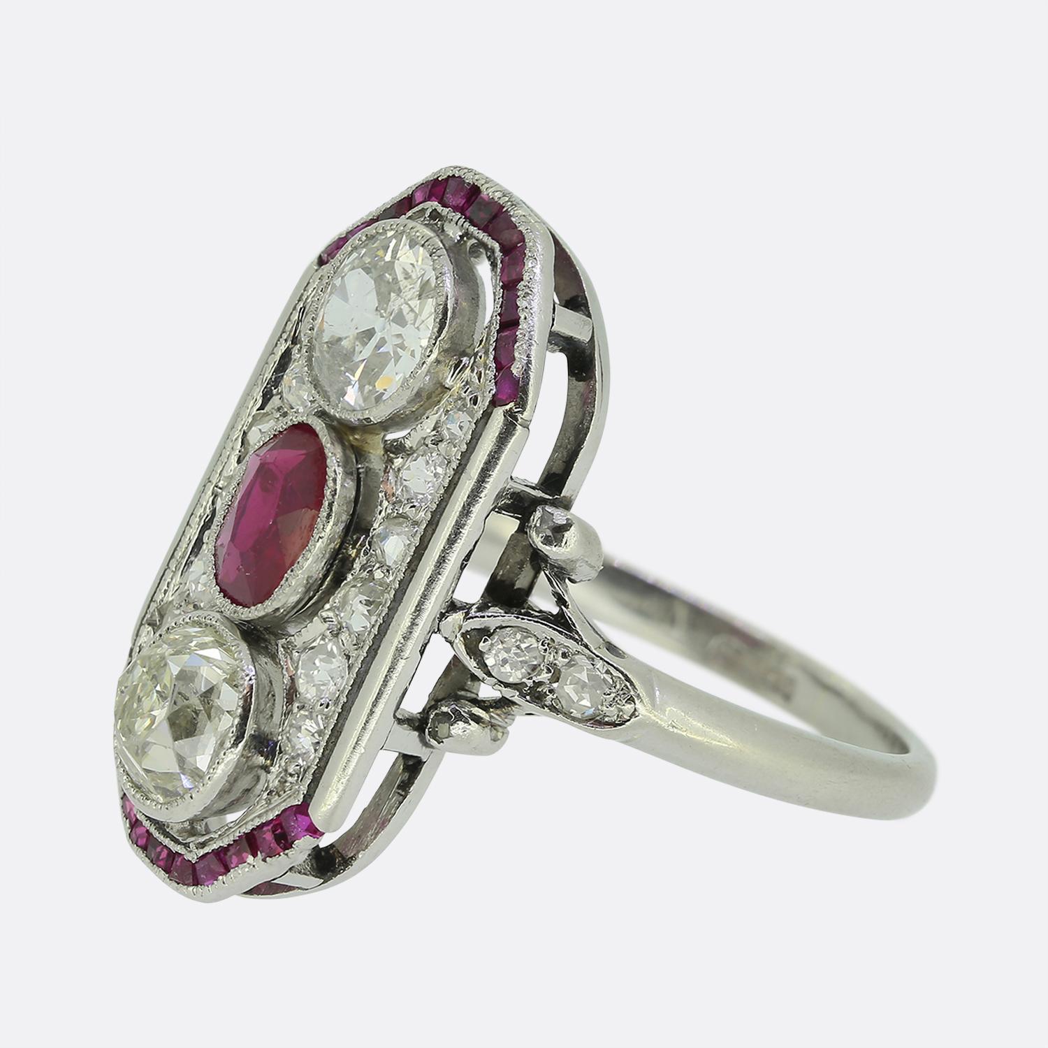 Aquí tenemos un llamativo anillo de vestir Art Déco. Esta pieza de gran tamaño exhibe un rubí rojo intenso en el centro de la cara, acompañado de un dúo de diamantes redondos de talla europea antigua, creando un llamativo contraste. El diseño