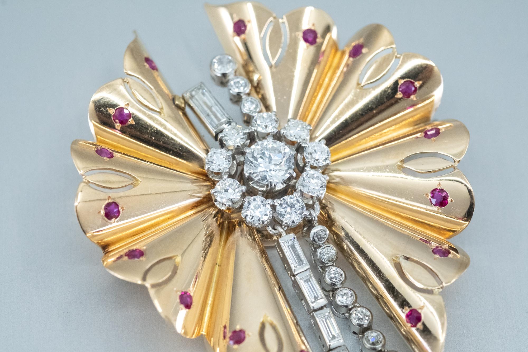 Una spilla Art Deco con diamanti e rubini. 

La spilla con diamanti e rubini ha la forma di una farfalla ed è incastonata con rubini naturali nelle ali e diamanti di varie forme sul corpo e sulle code. 
Tutti incastonati in oro giallo e bianco 18ct.