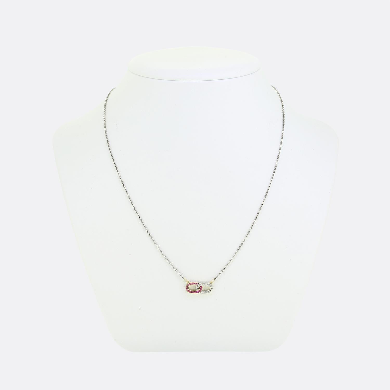 Here we have a charming Art Deco necklace showcasing a fabulous open design with interlocking ovals. One oval is adorned with square calibrated rubies showcasing a rich red colour with pinky undertone. This is contrasted beautifully with the other