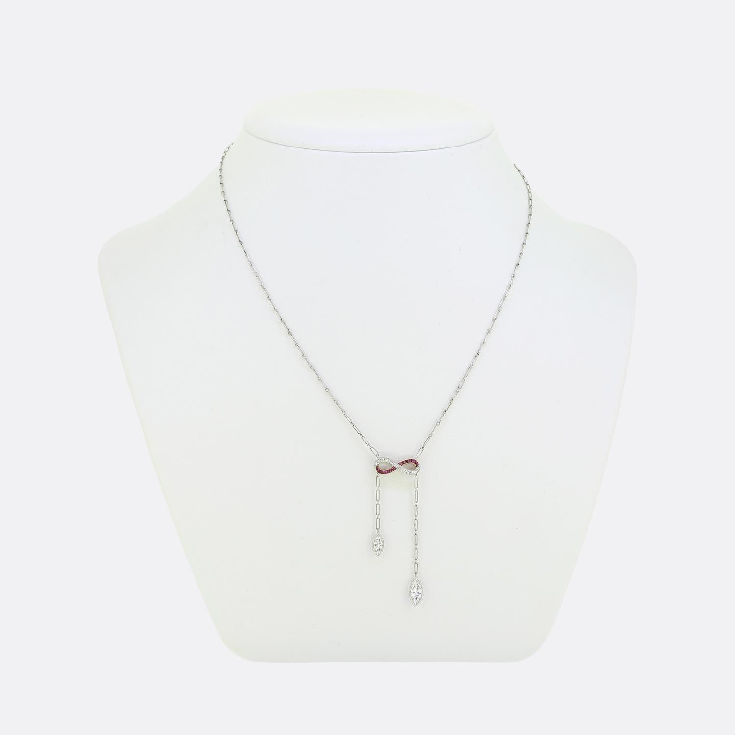 Qui abbiamo una dolce ed elegante collana negligé presa dall'epoca Art Deco. Questo gioiello in platino presenta un motivo a forma di infinito al centro, ornato da ricchi rubini rossi e da una fila di diamanti taglio old mine. Due brillanti diamanti
