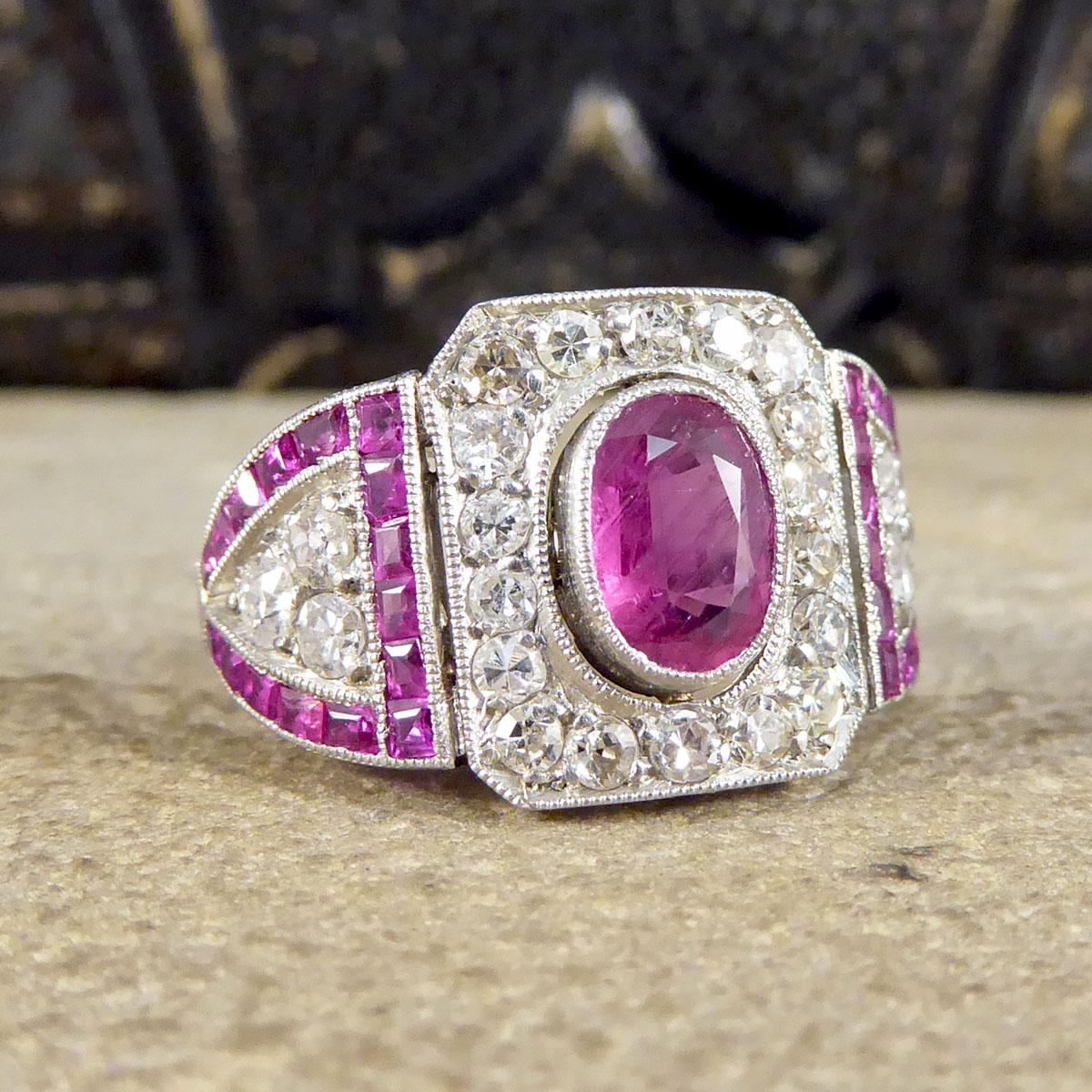 A stunning Platinum ring that was made in circa 1920, a perfect example of a fine Art Deco piece. It has a lovely colour Ruby in the centre with the Calibre Cut Rubies on the shoulders matching the colour perfectly. The centre Ruby weighs 0.75ct and
