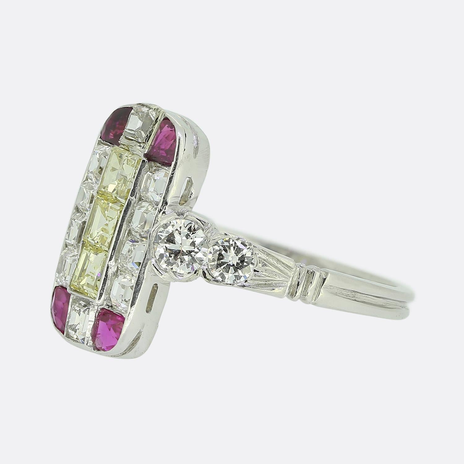Here we have a superb ruby and diamond tablet ring crafted at a time when the Art Deco style was at the height of design. This platinum piece showcases an elongated oval face set with a geometric array of precious stones including yellow princess