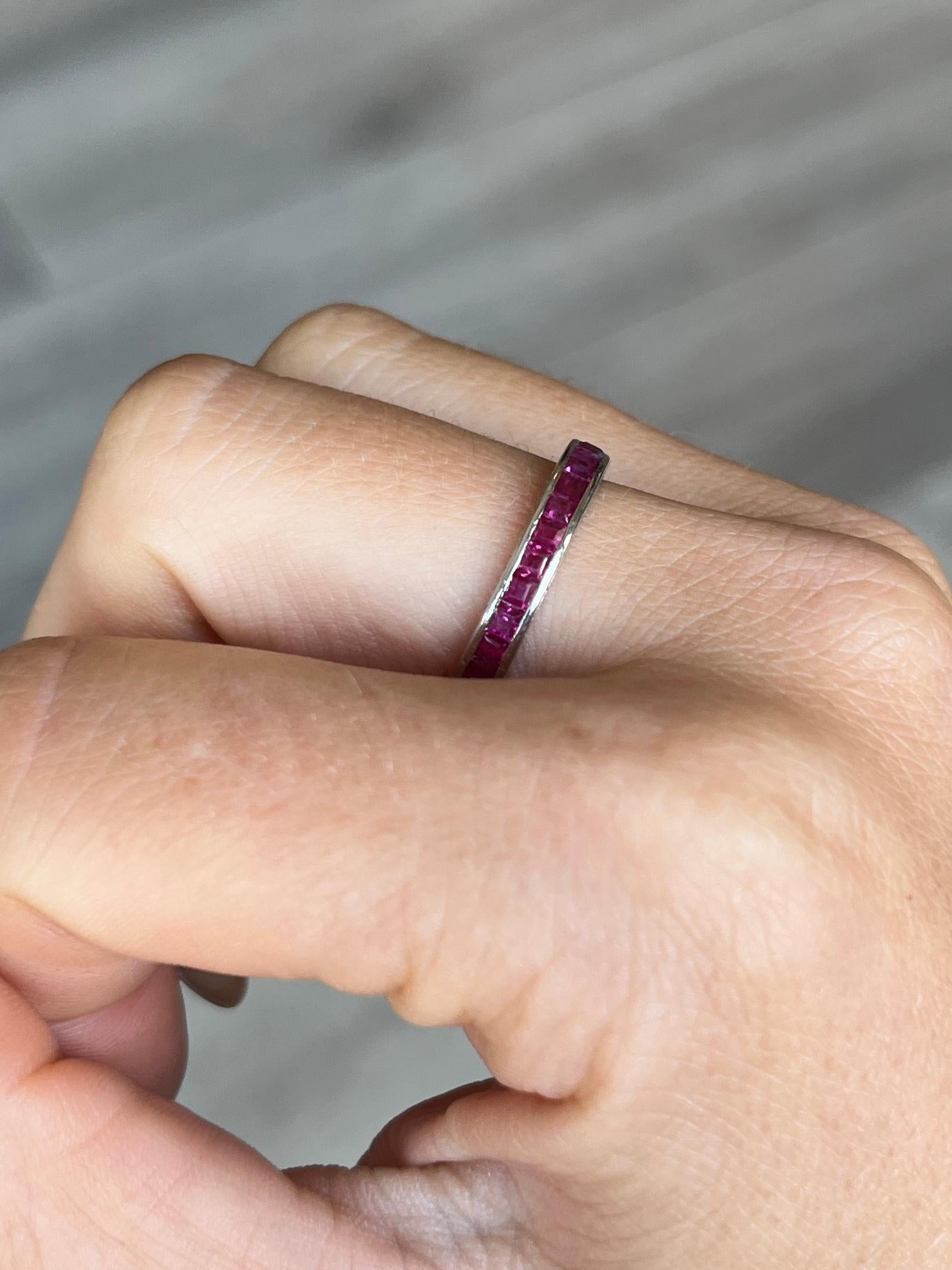 The rubies in this eternity band are a beautiful cherry pink colour and are set within the platinum band. The band has fine engraving on either side of it and the stones total approx 1.5ct. 

Ring Size: M or 6 1/4 
Band Width: 3.5mm 
Height off