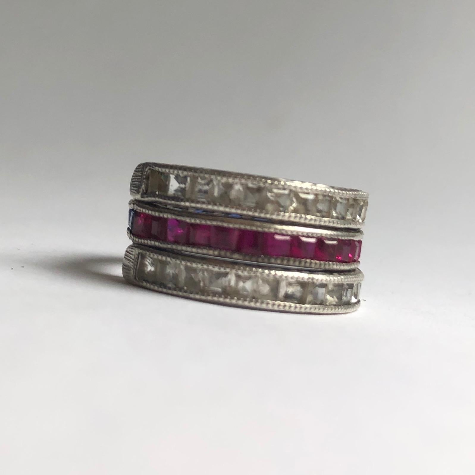 This gorgeous day to night eternity band holds a central band which holds half a band of rubies and half blue sapphires. These stones measure 5pts each. Either side of the ruby and sapphire band there are two bands holding white sapphires which can