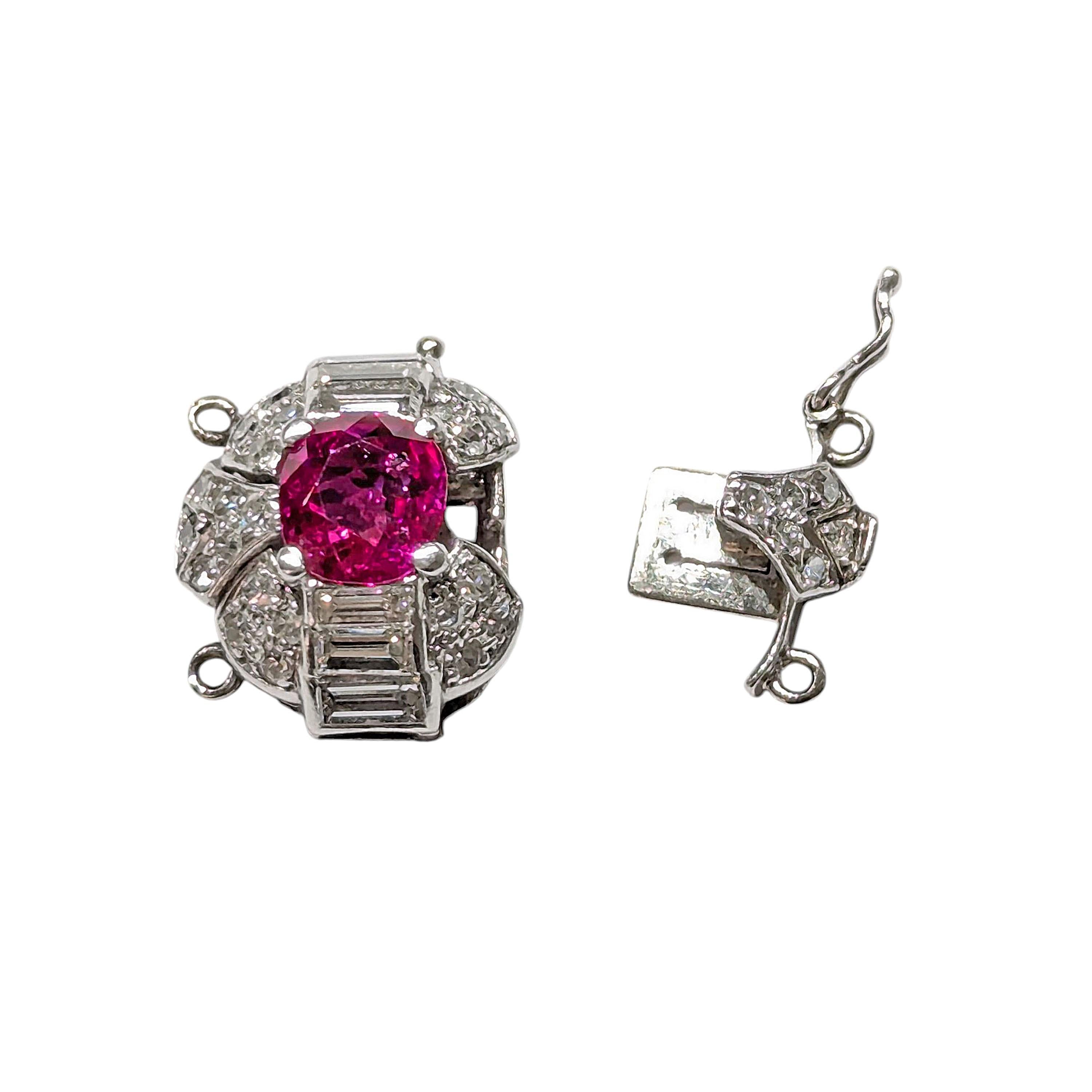 Chiusura Art Deco in rubino, diamanti e platino, con un rubino Burma ovale sfaccettato al centro, con un contorno di diamanti incastonati, comprendente tre diamanti graduali taglio baguette, in incastonature a canale, sopra e sotto il rubino,