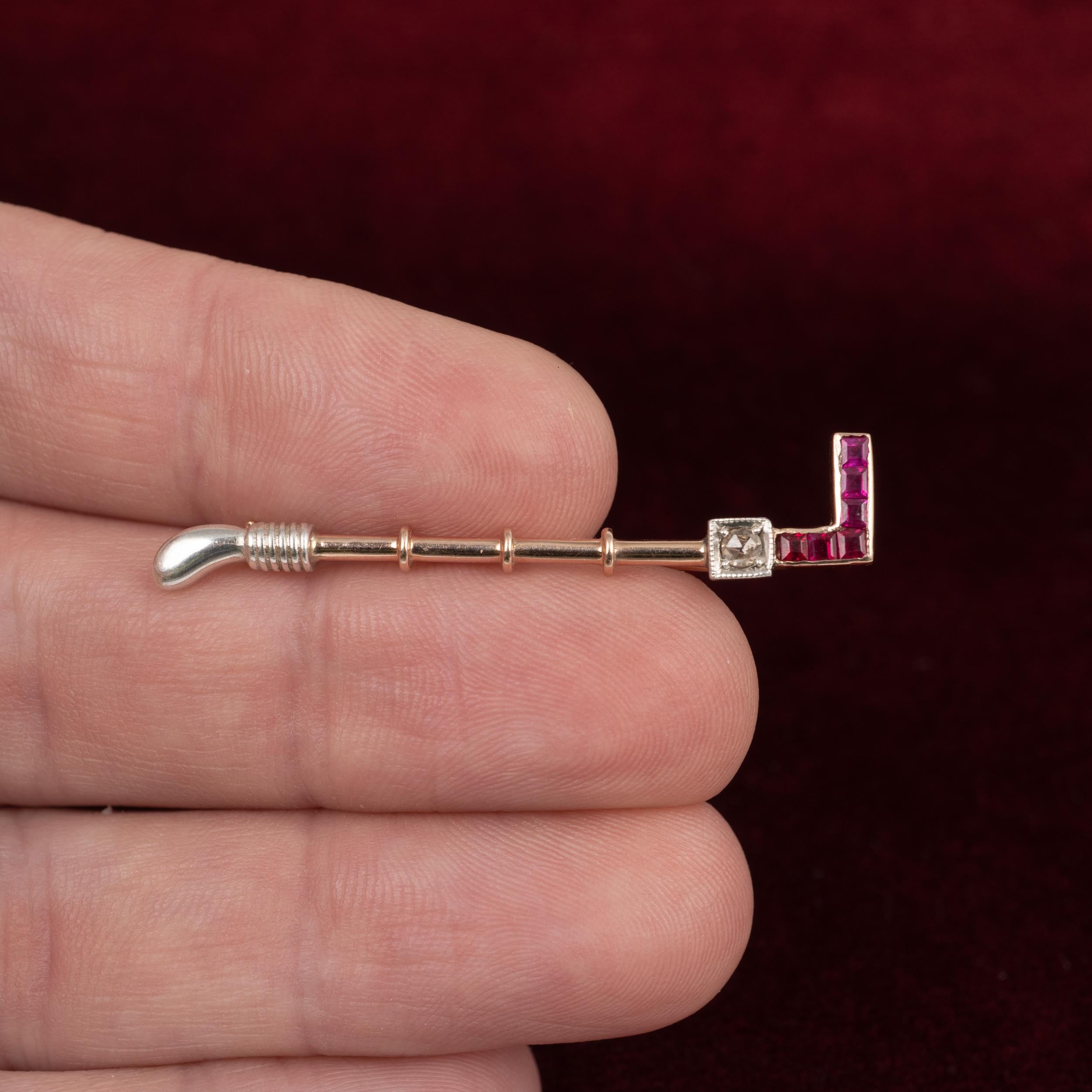 A fabulous Art Deco riding crop brooch set with square-cut rubies and old cut diamond, 18 karat rose gold and platinum, Circa 1920s.

Metal: 18 karat rose gold and platinum. Pin is made in 9 karat gold and stamped as such.
Size: 4.6 cms in