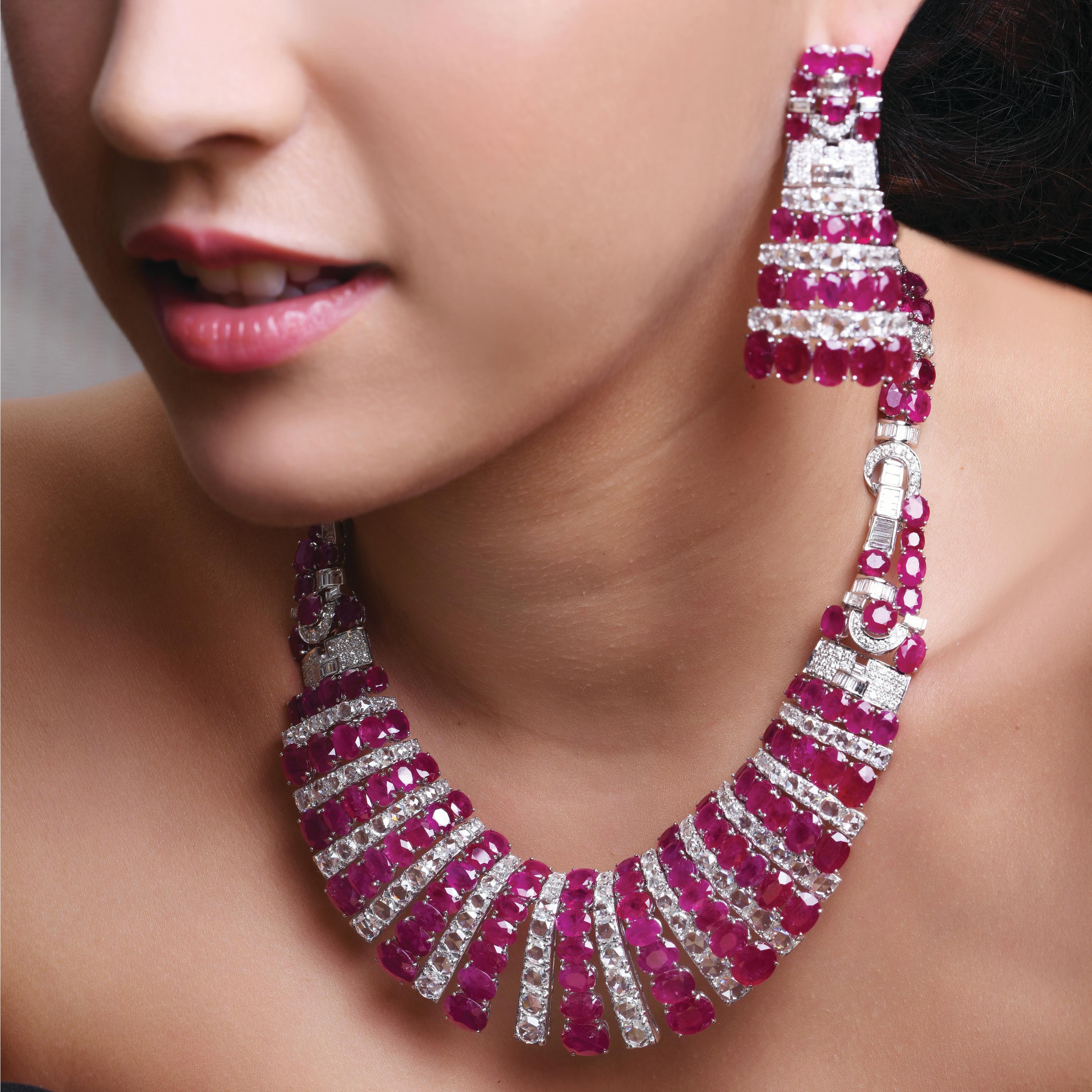 An Art Deco ruby and diamond suite of a necklace and a pair of earrings designed as a graduating series of pave set rubies  (159.81carats) and rose cut and full cut diamonds (32.75 carats) mounted in 18k yellow gold.