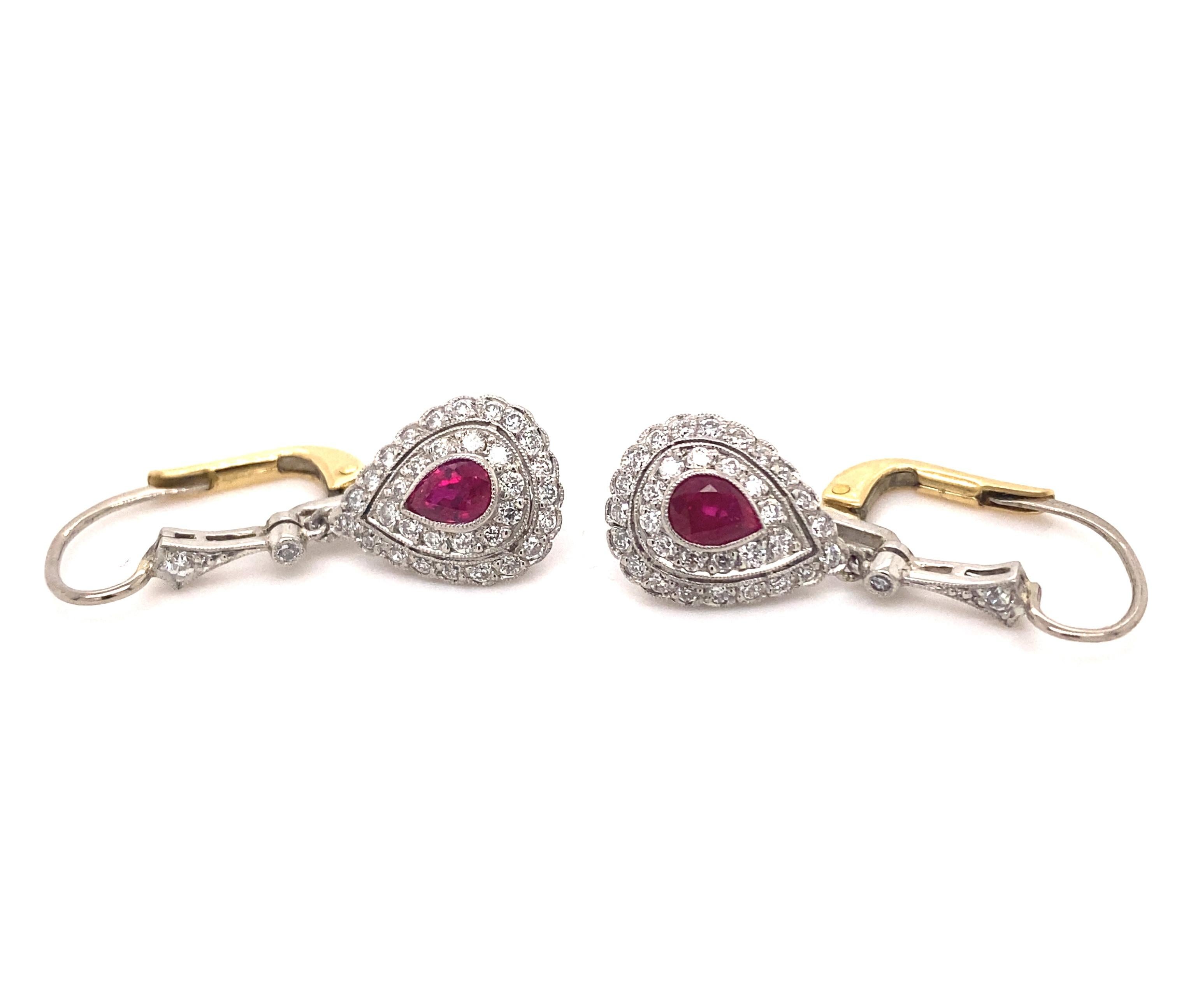 This is a beautiful pair of vintage art deco dangle earrings with rubies and diamonds set in platinum with 18k gold backs. The pear shaped rubies have amazing deep red color with good clarity estimated carat weight .90 carats. The 64 white diamonds