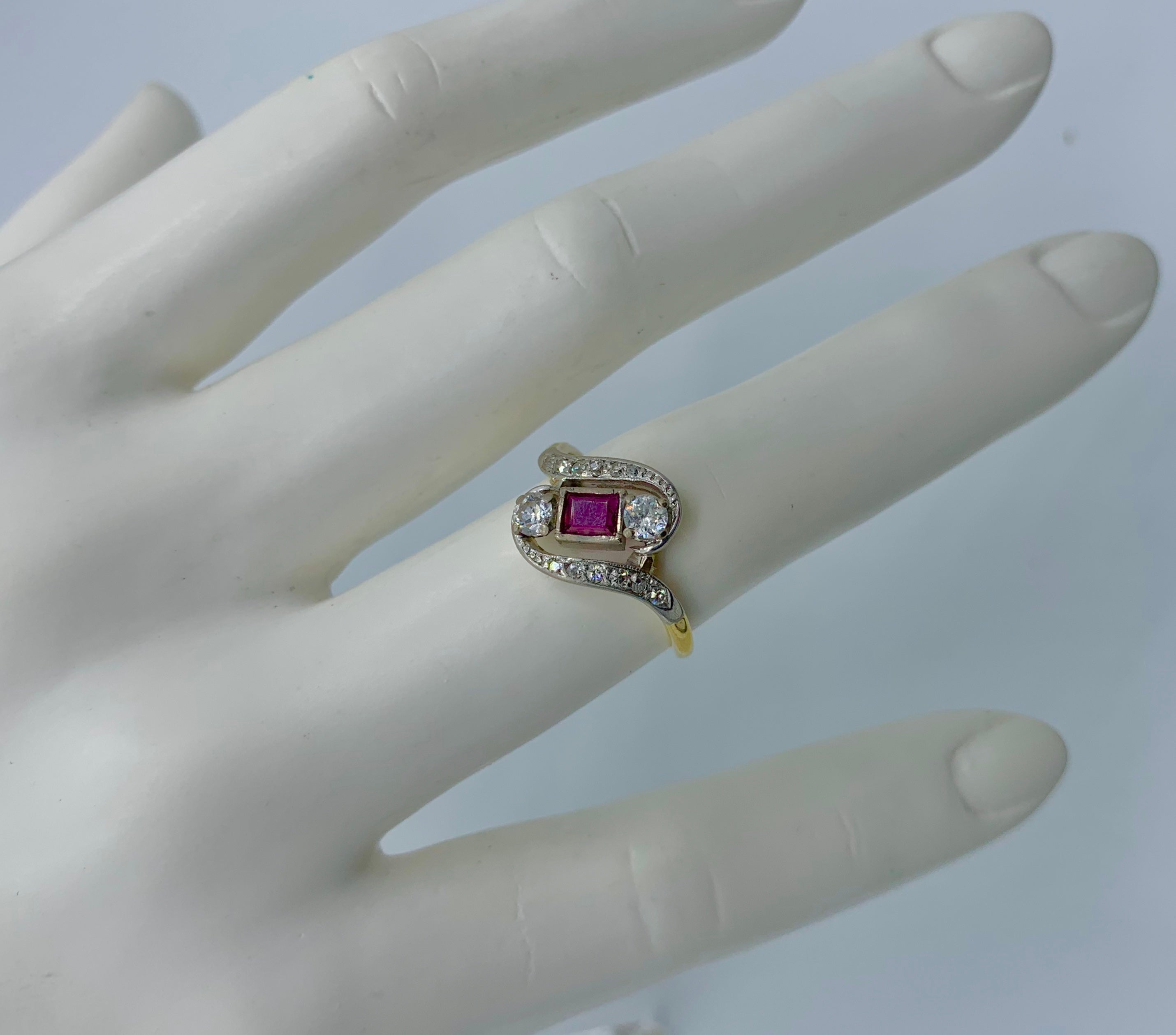 This is an Antique Victorian - Art Deco Ring with a gorgeous natural emerald cut Ruby and Diamonds of stunning beauty. The open work swirling design of the period Art Deco ring is absolutely wonderful and is very rare.  The color of the Ruby is the