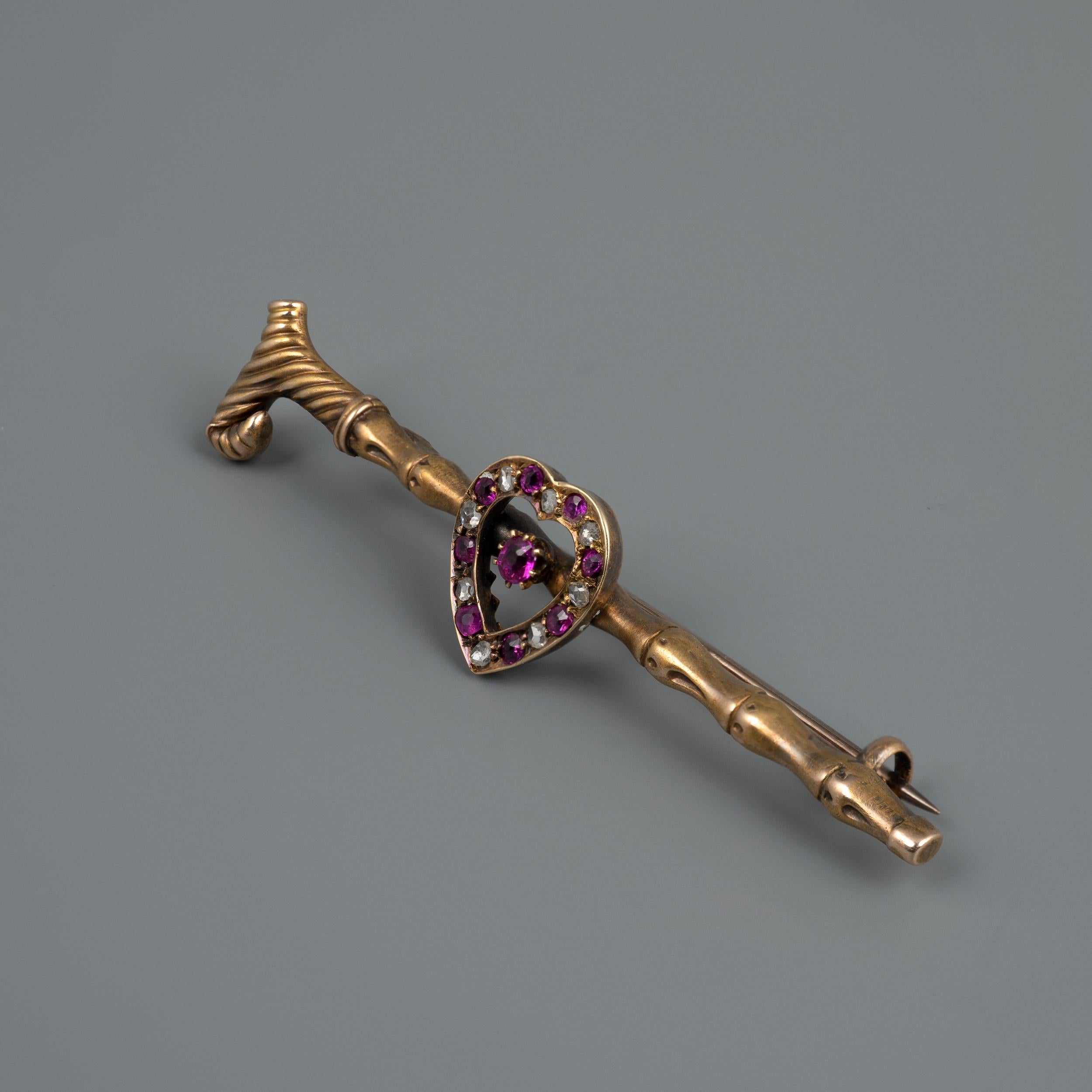 A delightful antique 15ct gold brooch pin, in the form of a walking cane with heart, set with ruby and diamonds, circa 1920s

The splendid and unique piece is crafted as a bamboo walking cane with a chased handle. The centrepiece open heart is