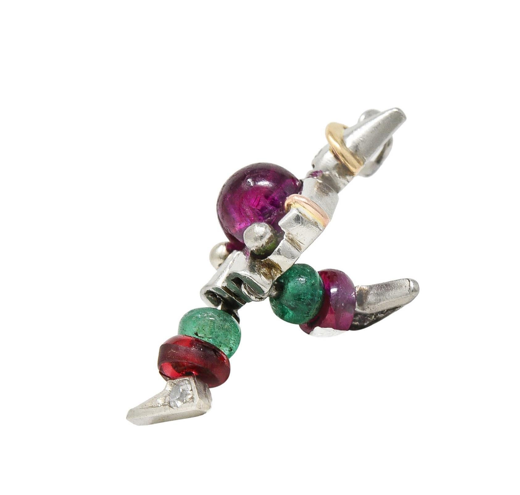 Designed as a stylized platinum clown with yellow gold details and articulating legs
Centering a round shaped ruby cabochon weighing approximately 0.72 carat
Transparent medium purplish red in color - bezel set as torso 
With ruby and emerald