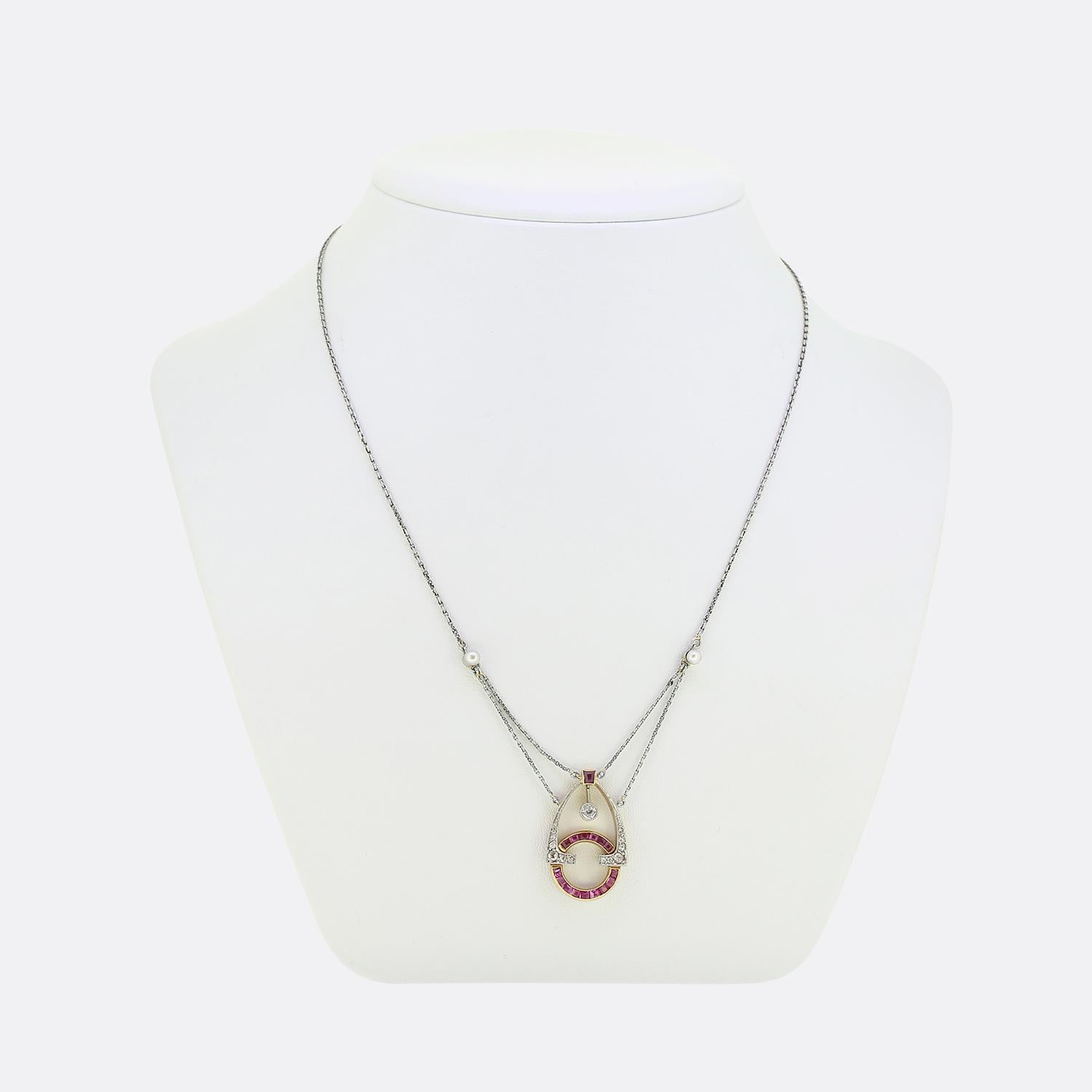 Nous avons ici un collier unique issu de l'époque Art déco. Cette pièce en platine est ornée d'un pendentif en forme de halo de rubis calibré au centre, d'une teinte rouge frappante parfaitement assortie à une nuance rosée. Autour de ces rubis,