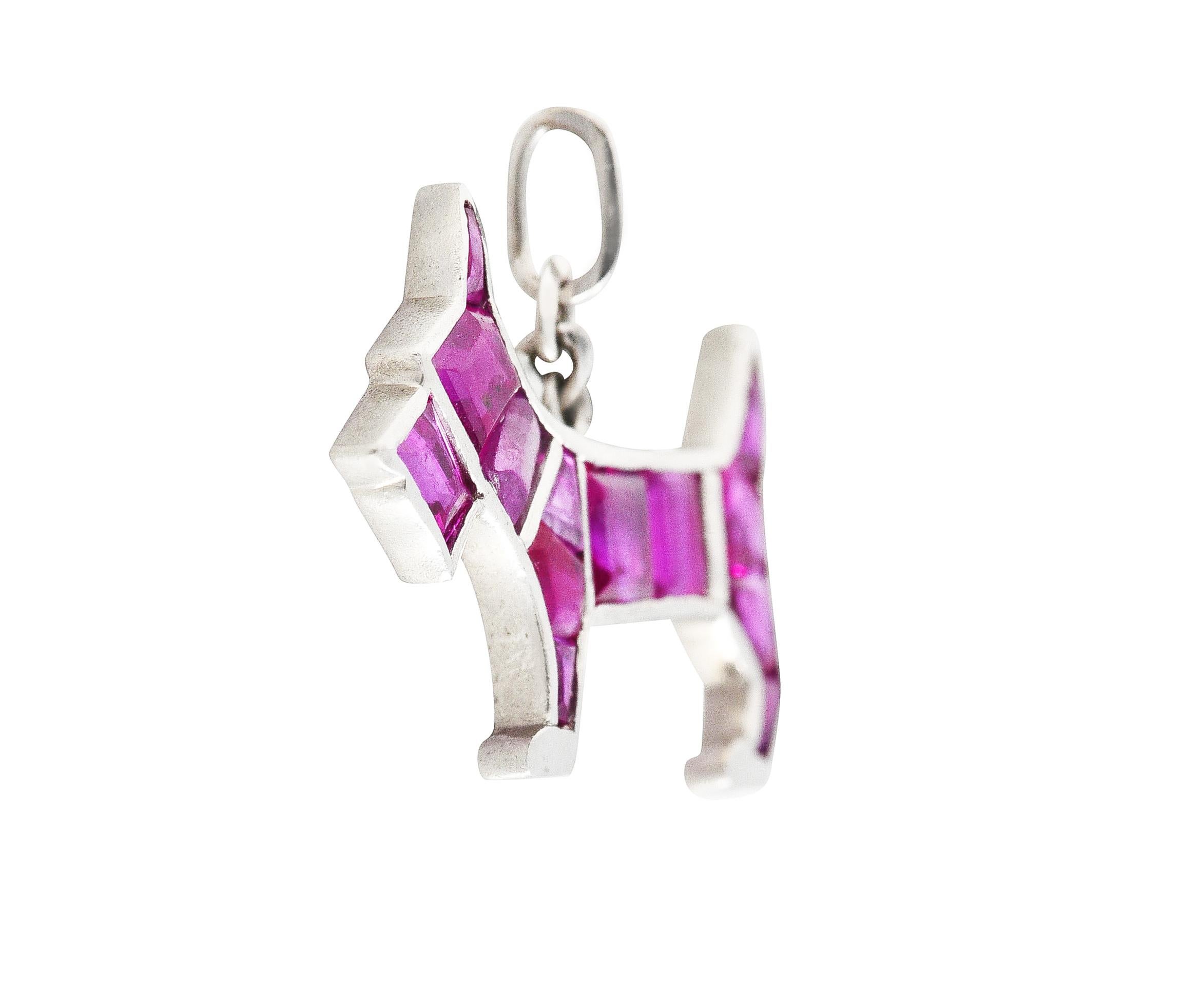 Charm is a Scottish Terrier dog with a stylized platinum frame set with calibrè cut rubies. Rubies are very well matched in purplish red in color. Weighing collectively approximately 1.15 carats. Completed by a jump ring bale. Tested as platinum.