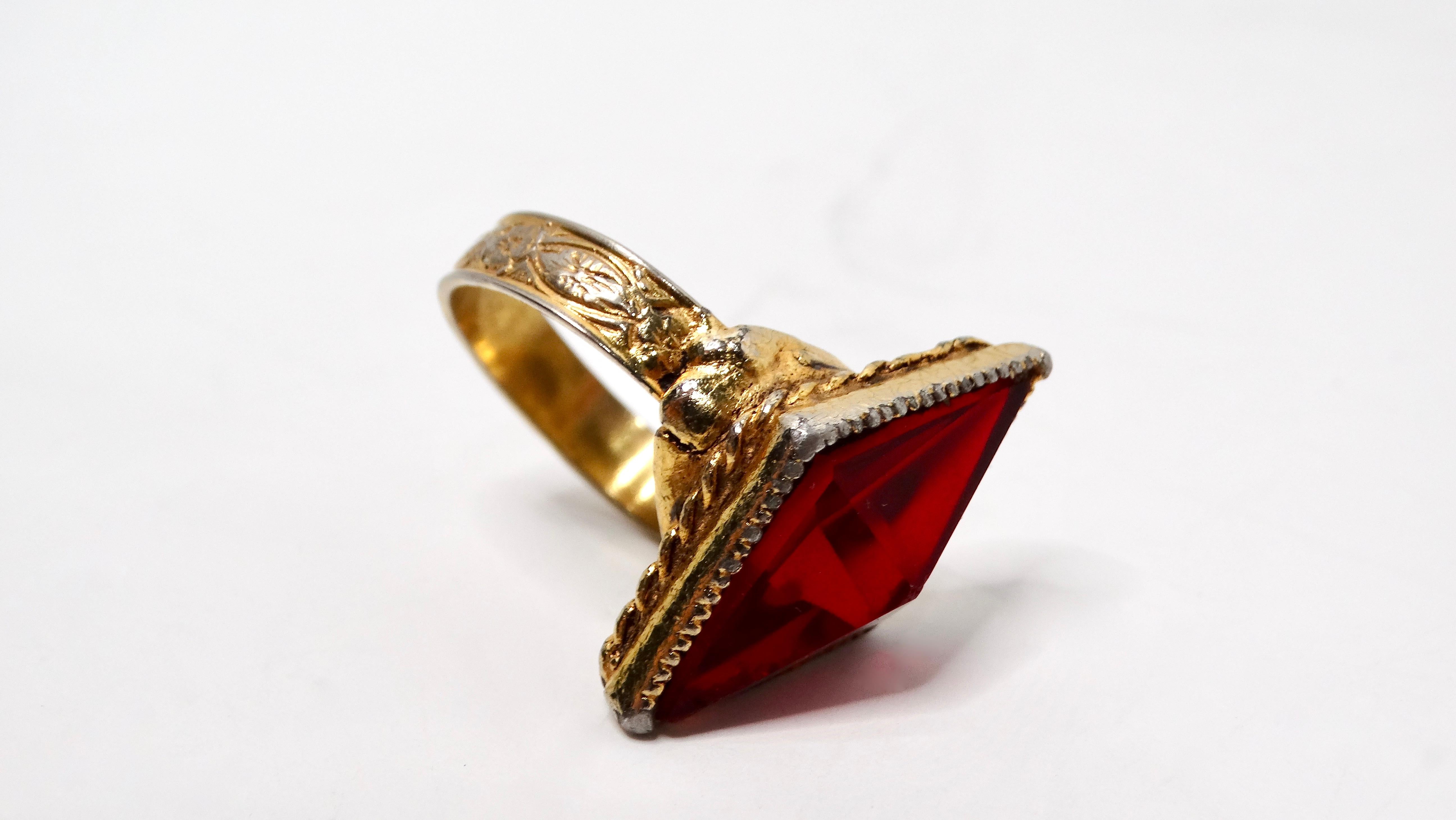 Make a statement with this exquisite Art Deco Ruby-Toned 14k Gold Plated Carved Detail Cocktail Ring. Featuring a striking diamond-shaped ruby rhinestone centerpiece, this piece exemplifies the elegance and glamour of the Art Deco era. The