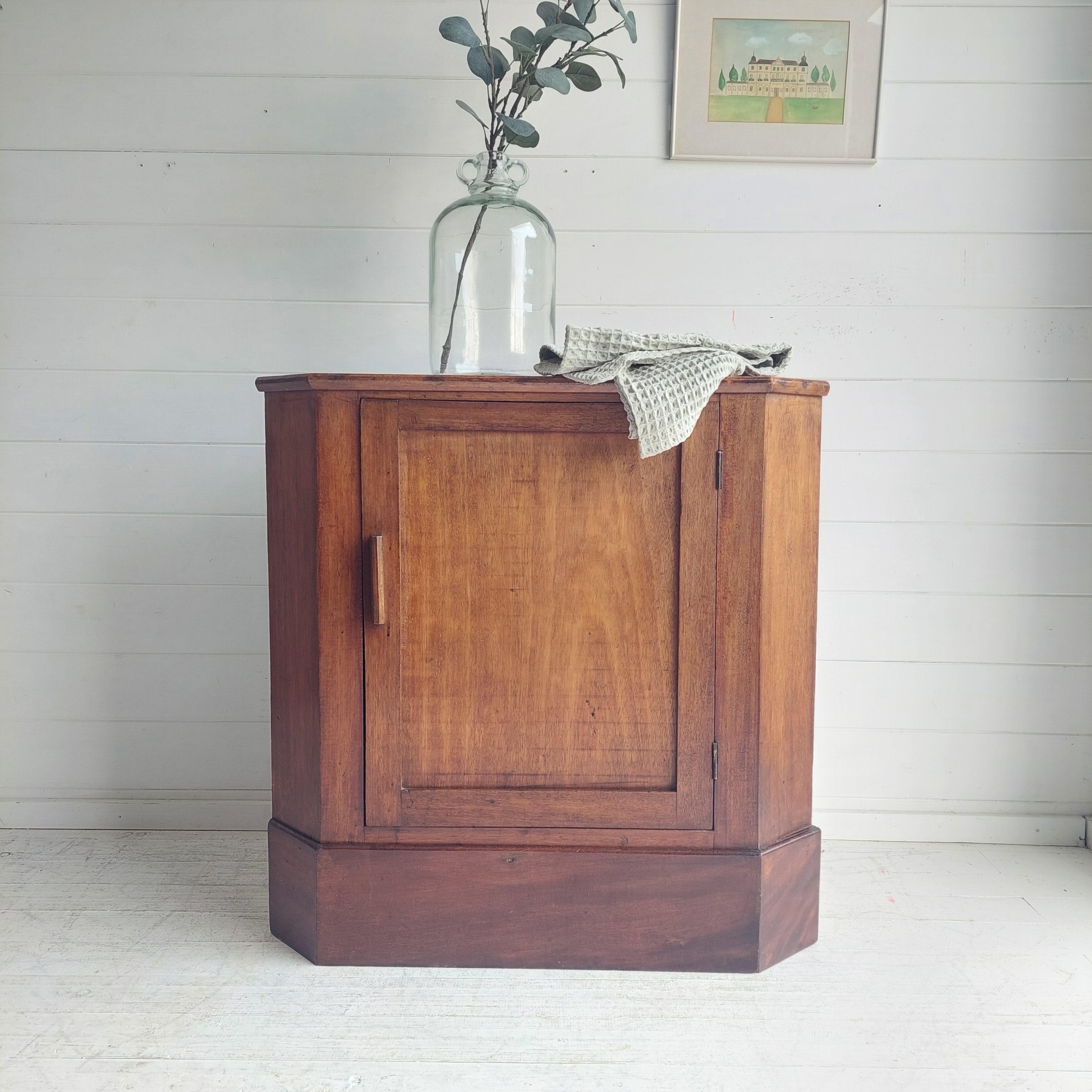 Late Victorian, Art Deco vintage mahogany corner unit.
Rustic country house feeling.

A desirable simply designed unit that will add character to any room.
Lovely piece with single paneled door and wooden geometrical carved handle.
Opens to reveal a