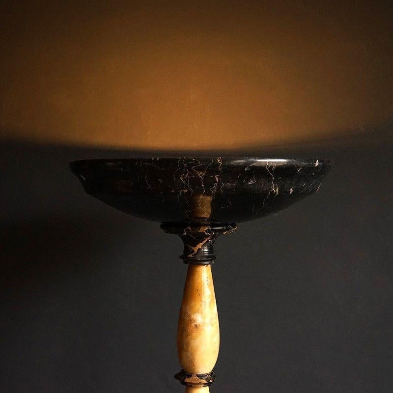 Art Deco black and golden marble standard lamp

Alternating pieces of contrasting highly characterful veined marbles. Italian golden egg yolk Sienna marble and French black Saint Laurent marble.

The top uplighter shade conceals two standard bayonet