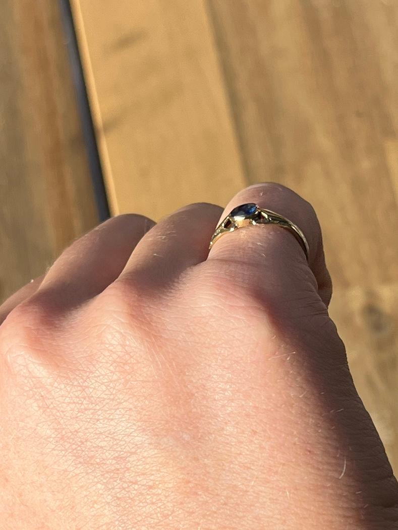 This ring holds one sapphire measuring 40pts and has decorative gold shoulders. The glossy gold band is modelled in 18ct gold.

Ring Size: G or 3 1/4

Weight: 1.6g