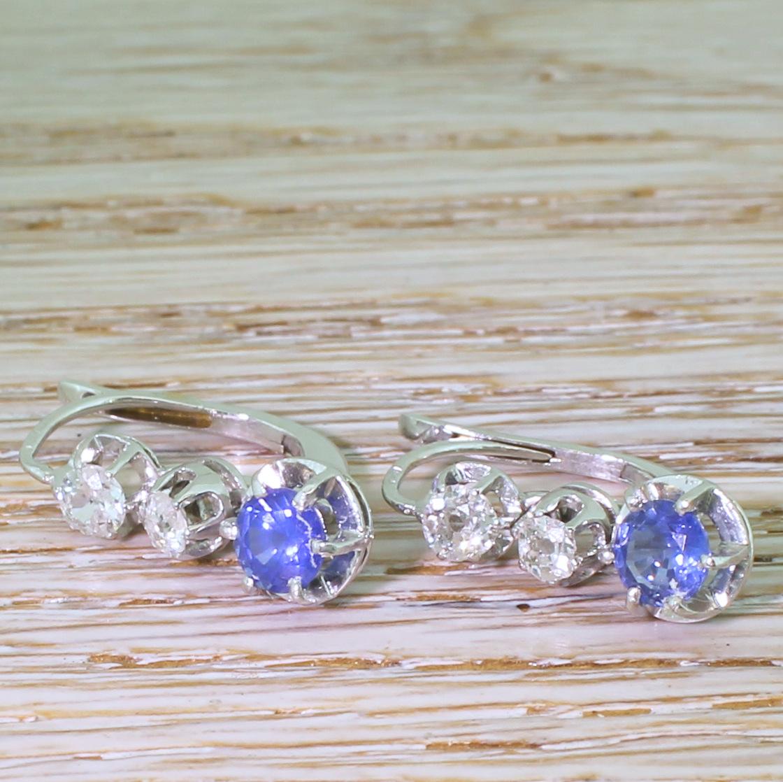 Highly beautiful vintage sapphire and diamond earrings. Each earrings holds two blindingly bright, colourless old cut diamonds leading – via an articulated drop – to a glowing, cornflower blue sapphire. All the gems are set in platinum, on a 18k