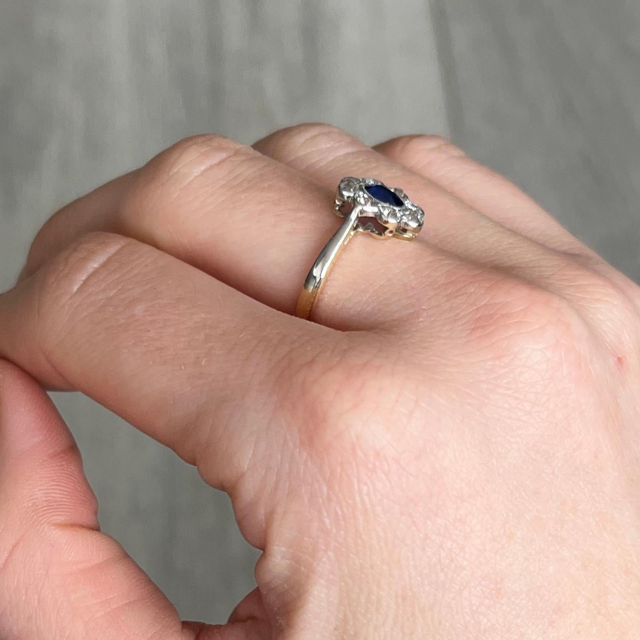 Dieser klassische Clusterring besteht aus einem zentralen Saphir und Diamanten an den Rändern, die alle in Platin gefasst sind. Der Saphir hat eine tiefblaue Farbe und misst 40 pt., die Diamanten insgesamt etwa 80 pt. 

Ring Größe: M 1/2 oder 6 1/2