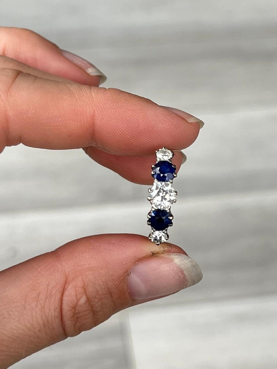 This gorgeous ring holds two deep blue sapphires measuring 35pts each and three diamonds. The central diamond measures 60pts and is H colour VS1 and the smaller diamonds measure 15pts each. The ring is modelled in 18ct gold and stones set in