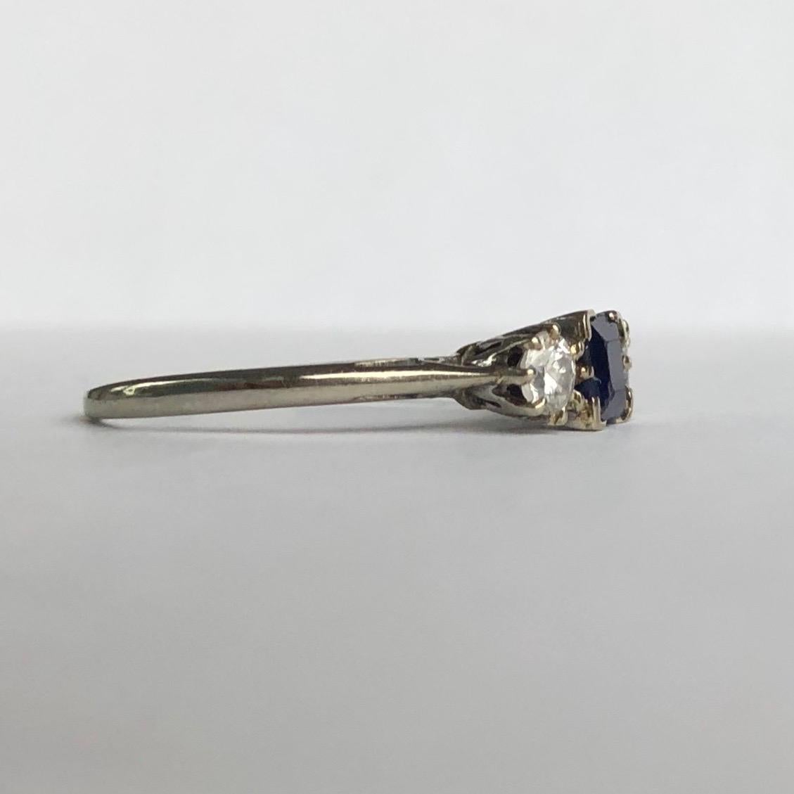 At centre of this three stone ring there is a gorgeous deep blue sapphire and sat either side is a bright sparkling diamond. The square cut sapphire measures 40pts and the old European cut diamonds measure 20pts each and are set in platinum.

Ring