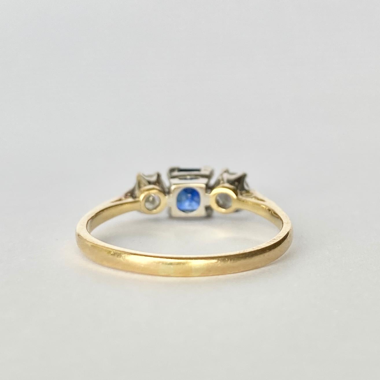 At the centre of this three stone ring there is a gorgeous bright blue sapphire and sat either side is a bright sparkling diamond. The square cut sapphire measures 50pts and the old European cut diamonds measure 20pts each and are set in