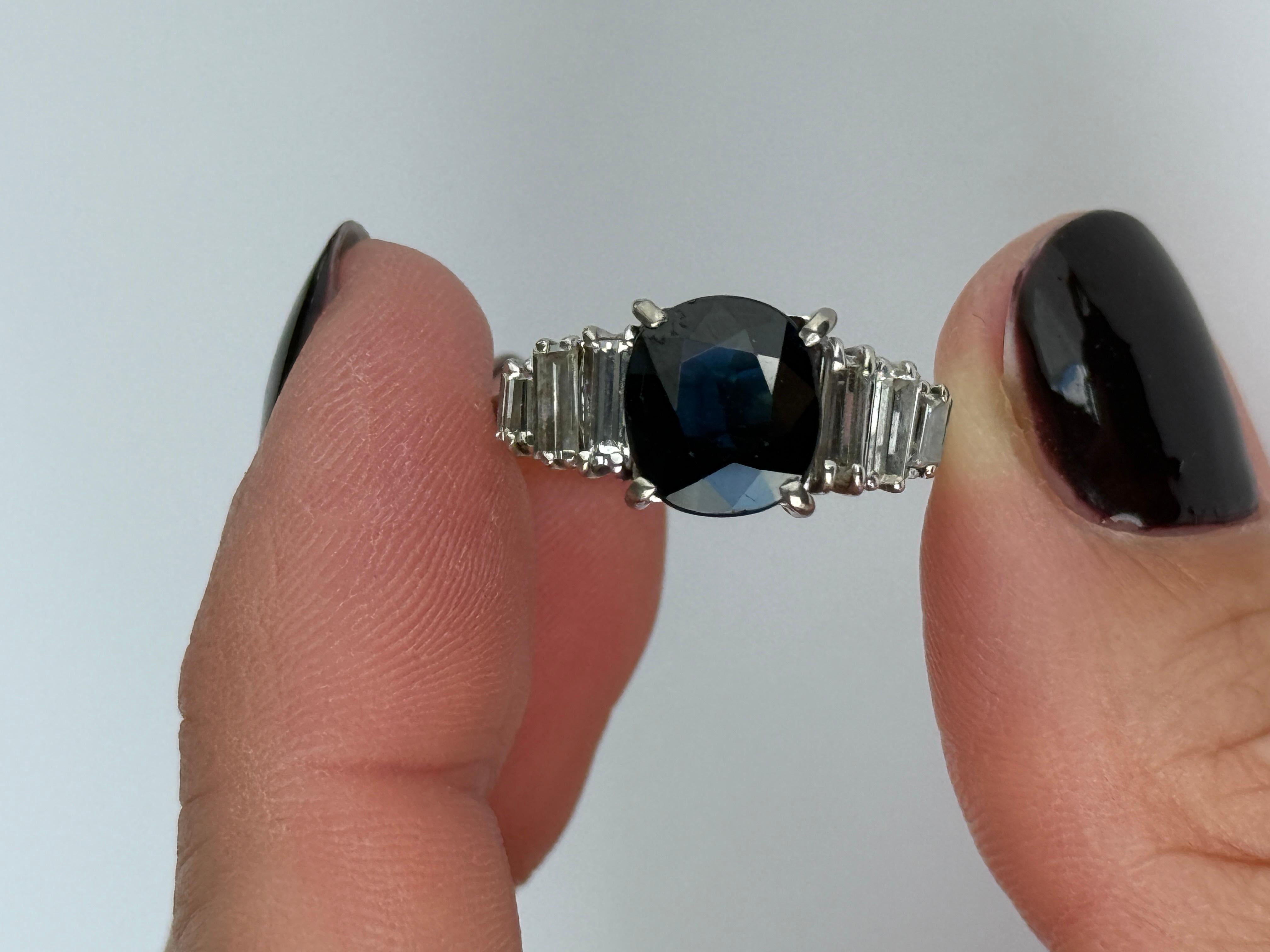 Cette bague est magnifique et contient un saphir bleu foncé et des diamants baguettes en épaulement. Le saphir mesure environ 2 carats et les épaulements mesurent 30pts par côté. 

Taille de l'anneau : K 1/2 ou 5 1/2 
Largeur de la face : 9