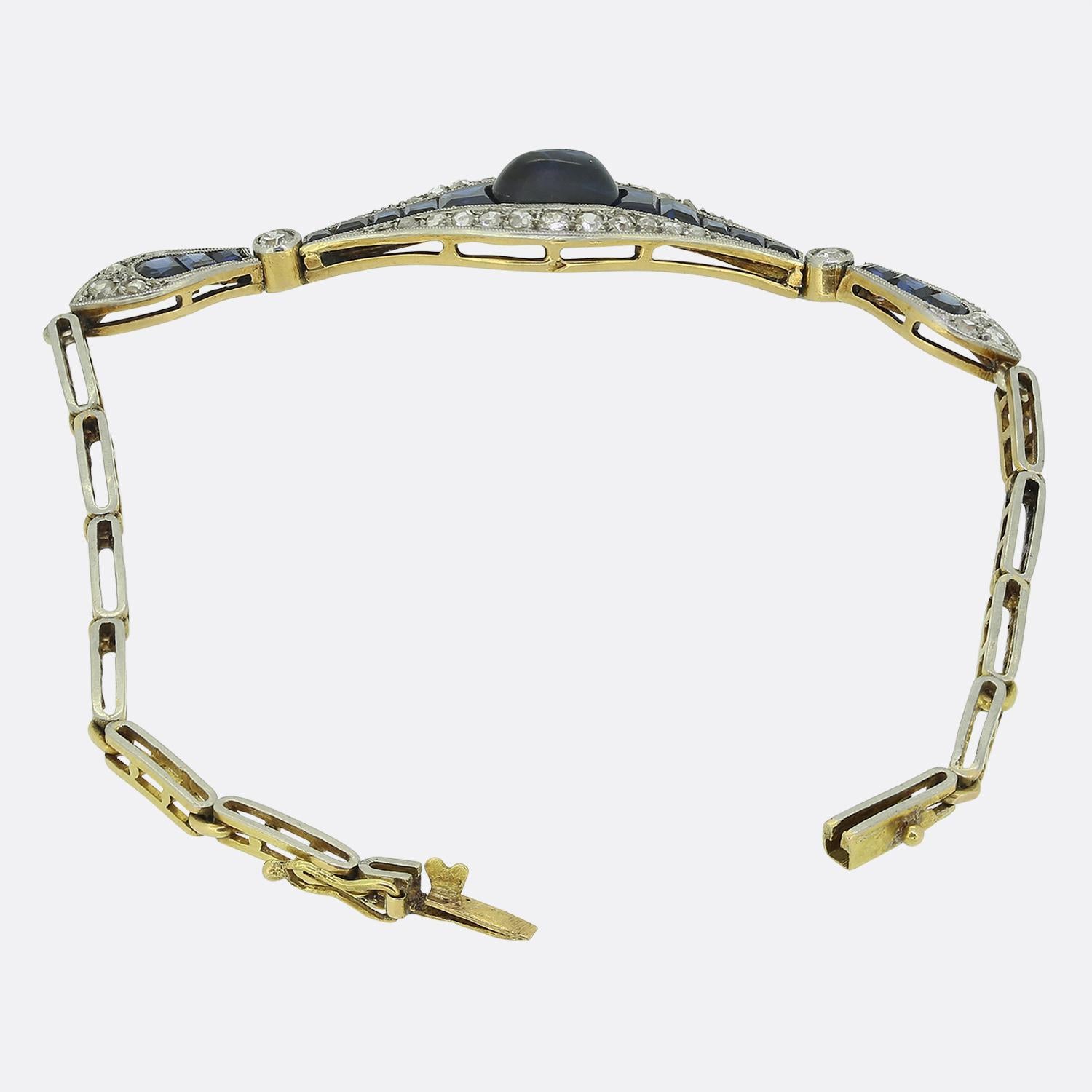 Aquí tenemos una sublime pulsera de zafiros y diamantes tomada de una época en la que el estilo Art Déco lideraba el diseño mundial. Esta pieza está elaborada en oro amarillo de 18 quilates y presenta una cadena eslabonada abierta que alberga un