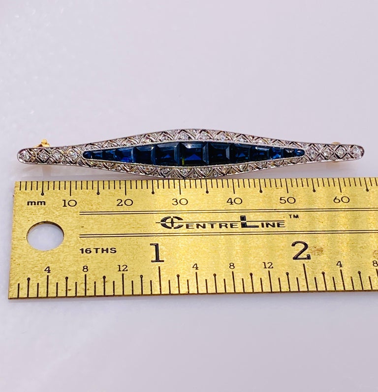 18k two-tone 3.2 carat total weight sapphire and .65 carat total weight diamond brooch pin. 65mm long, 3.5Dwt