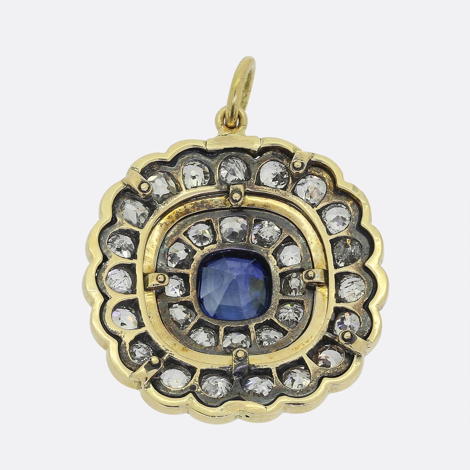 Ecco un favoloso ciondolo Art Déco. Questo pezzo è stato realizzato in oro giallo 18 carati e presenta uno zaffiro rotondo centrale con un'audace tonalità di colore blu naturale. Questa pietra principale è poi circondata da diverse cornici, tra cui