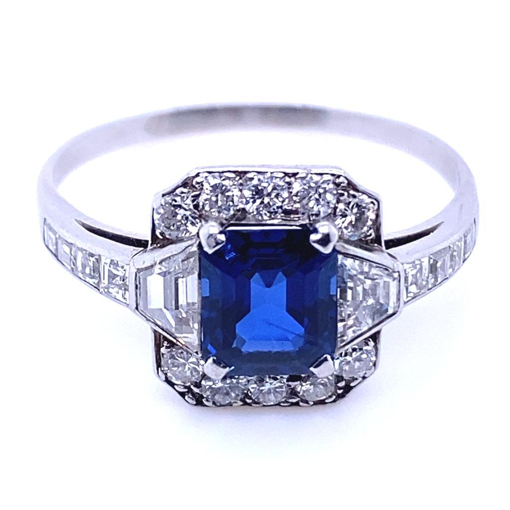 An Art Deco sapphire and diamond cluster platinum engagement ring

This beautiful Art Deco ring is set to its centre with a royal blue emerald cut sapphire with a classic diamond cluster to its top and bottom contrasting with elegant trapeze cut