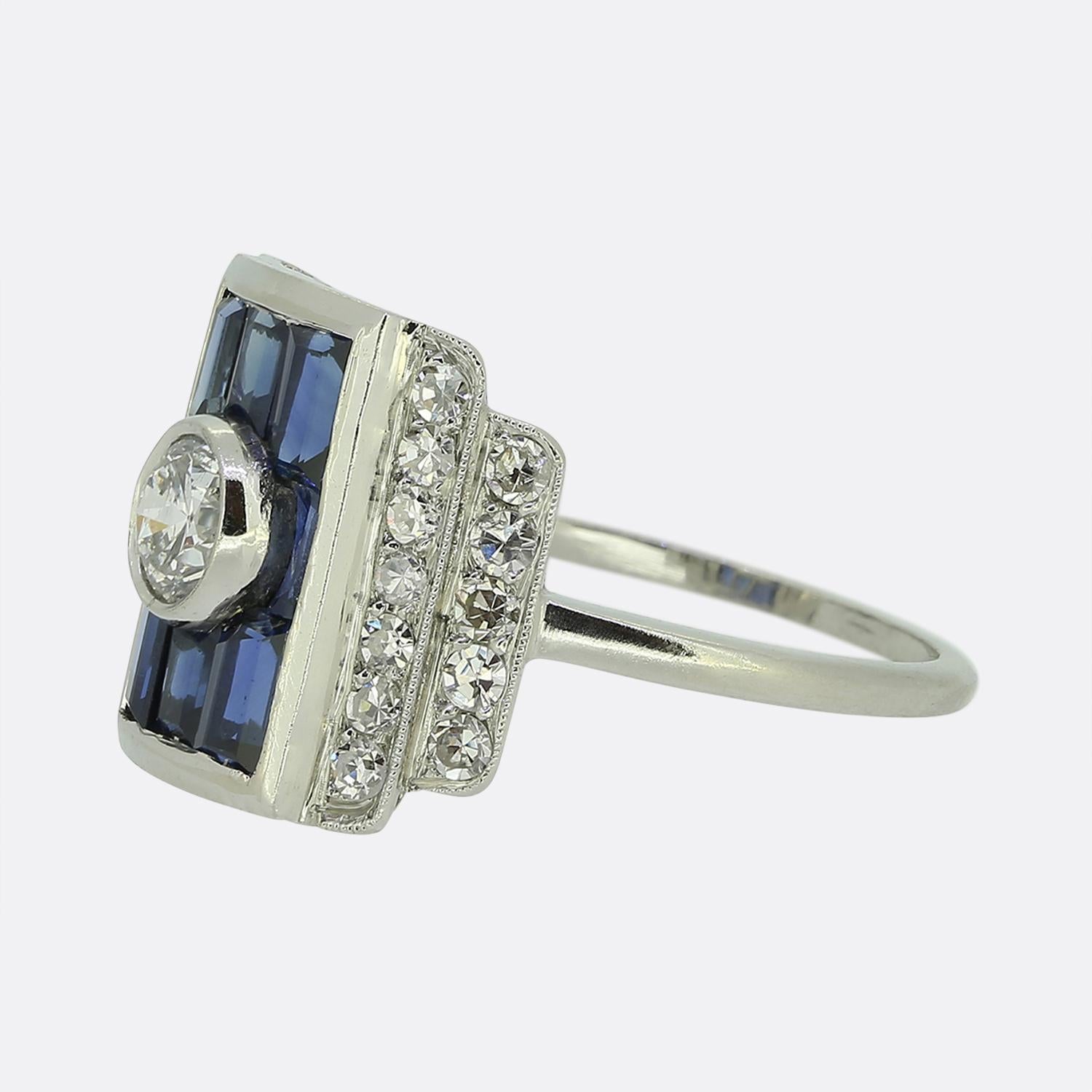 Here we have a fabulous sapphire and diamond cluster ring crafted during the pinnacle of the Art Deco movement. The face of this piece has been crafted from platinum into a concave boxed shape with a single round faceted old cut diamond at the