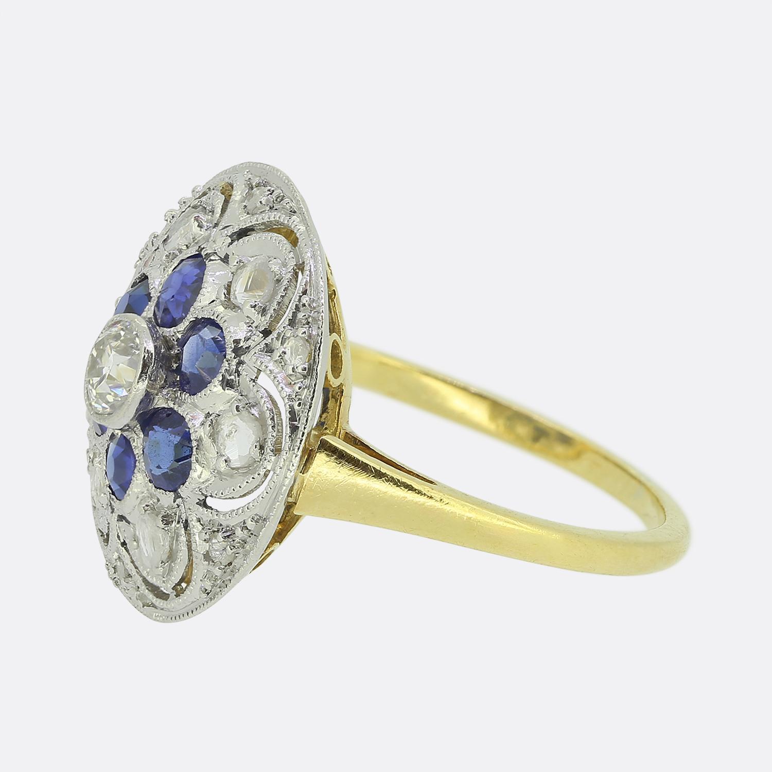 Here we have a delightful sapphire and diamond cluster ring taken from the pinnacle of the Art Deco movement. A single round faceted old mine cut diamond sits proud at the centre of the face in a bezel setting. This principal stone is then