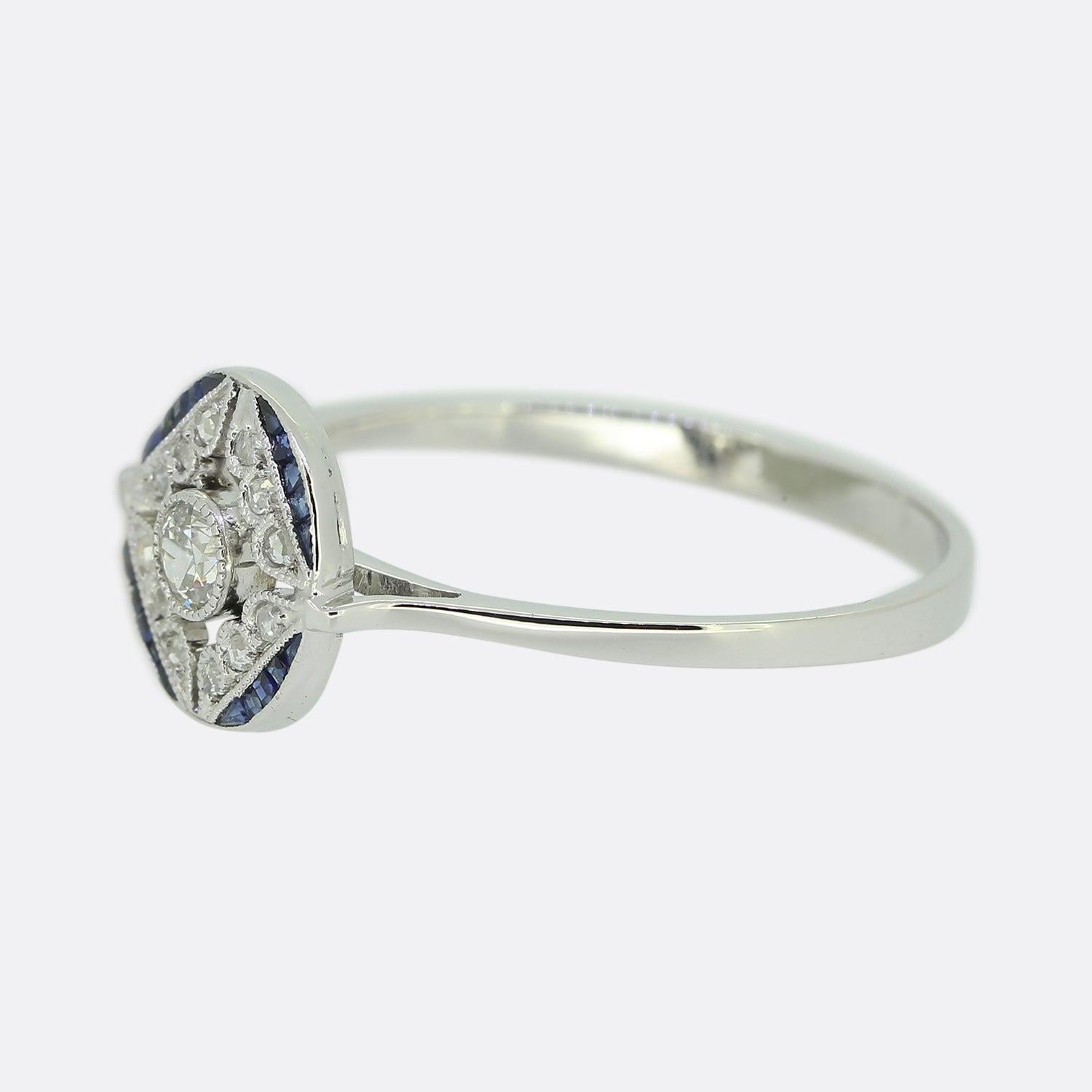 Here we have a wonderful sapphire and diamond ring crafted at a time when the Art Deco style was at the height of design. A single round brilliant cut diamond sits slightly risen at the centre of an open face in a fine milgrain setting. This
