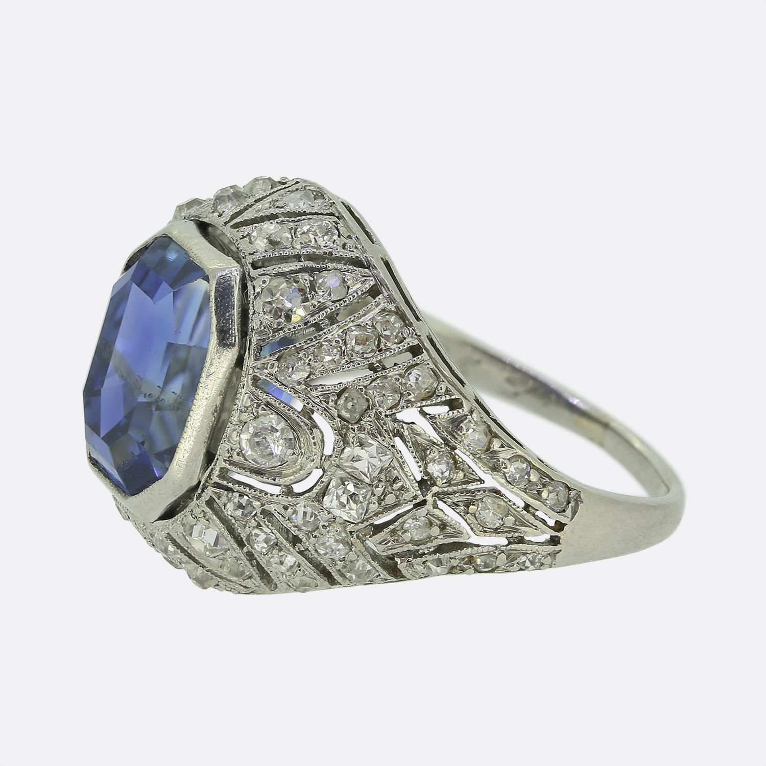 Here we have a sublime sapphire and diamond ring crafted during the height of the Art Deco movement. This platinum piece plays host to an impressive 5.00ct radiant-like cut sapphire of Ceylon origin which possesses a gorgeous cornflower blue colour